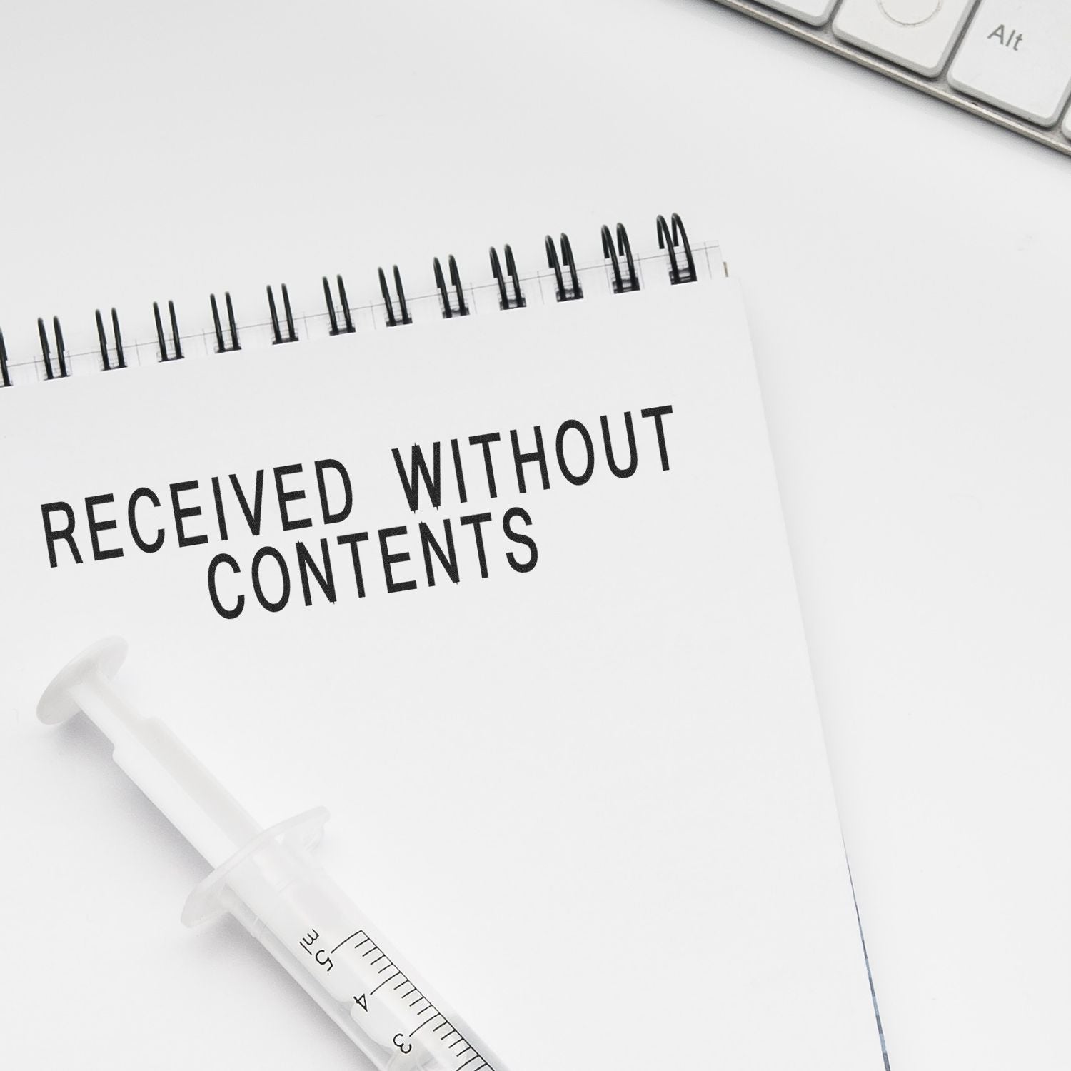Minimalist medical concept with a notebook reading Received Without Contents and a syringe on a white desk background