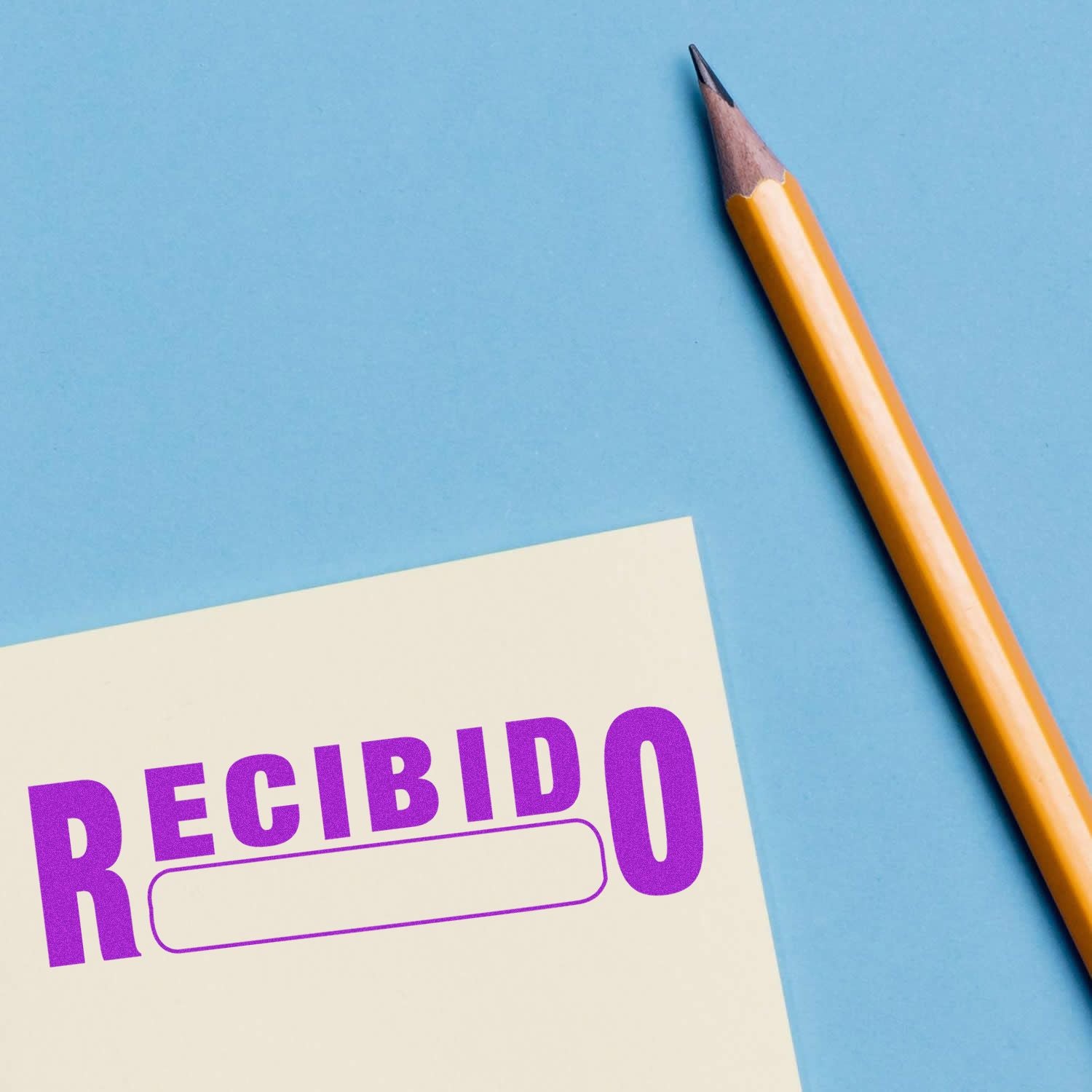 Pencil beside a Recibido stamp on paper, blue background, office and document approval concept.