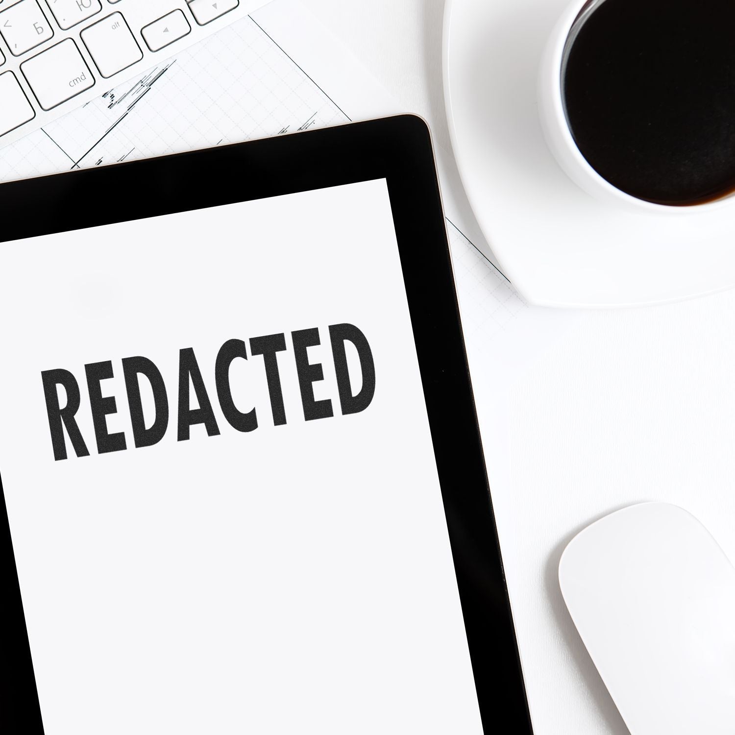 Laptop screen displays REDACTED for privacy and data redaction, with keyboard and coffee, illustrating secure document editing.