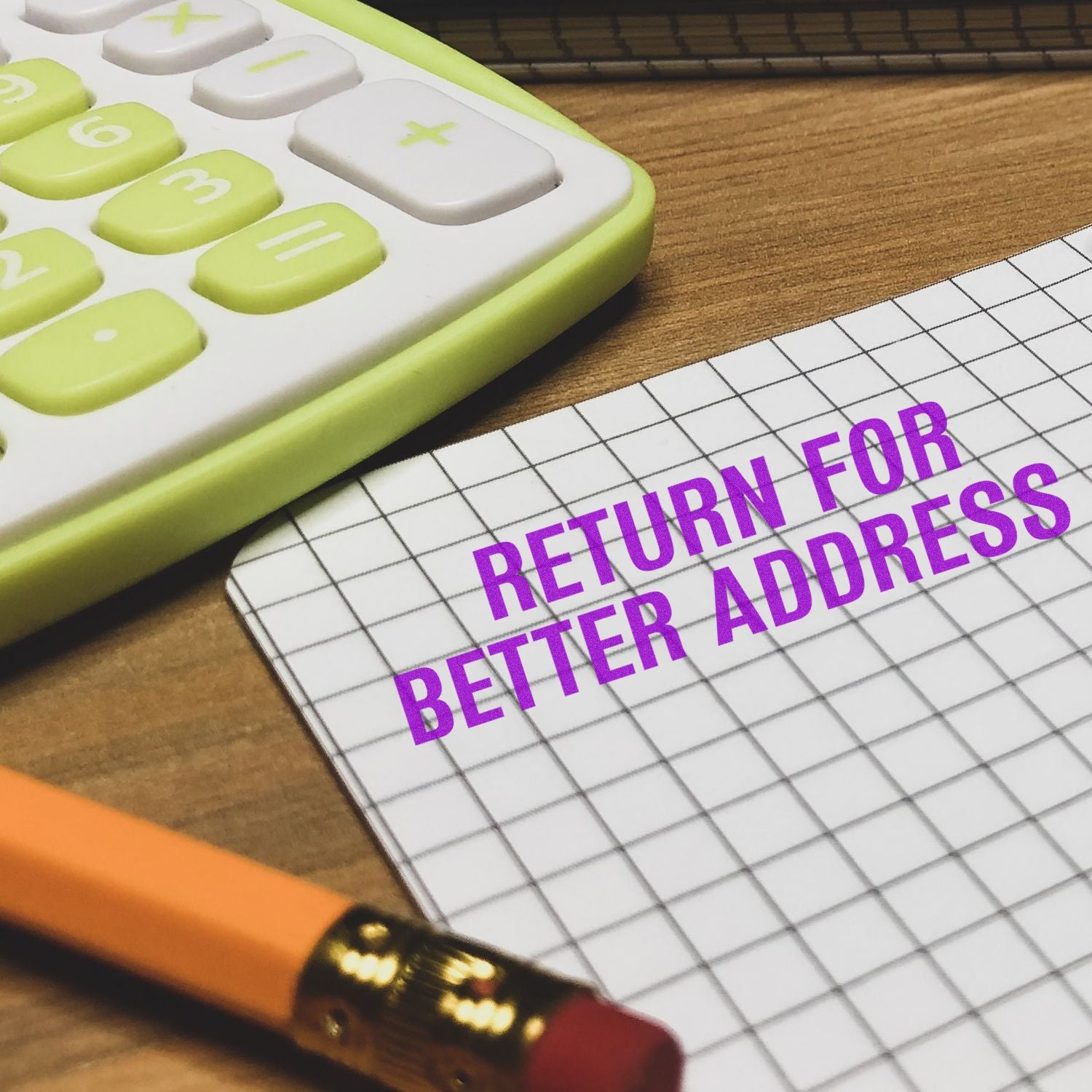 Calculator beside a note reading Return for Better Address on a desk, concept of address correction and mail return.