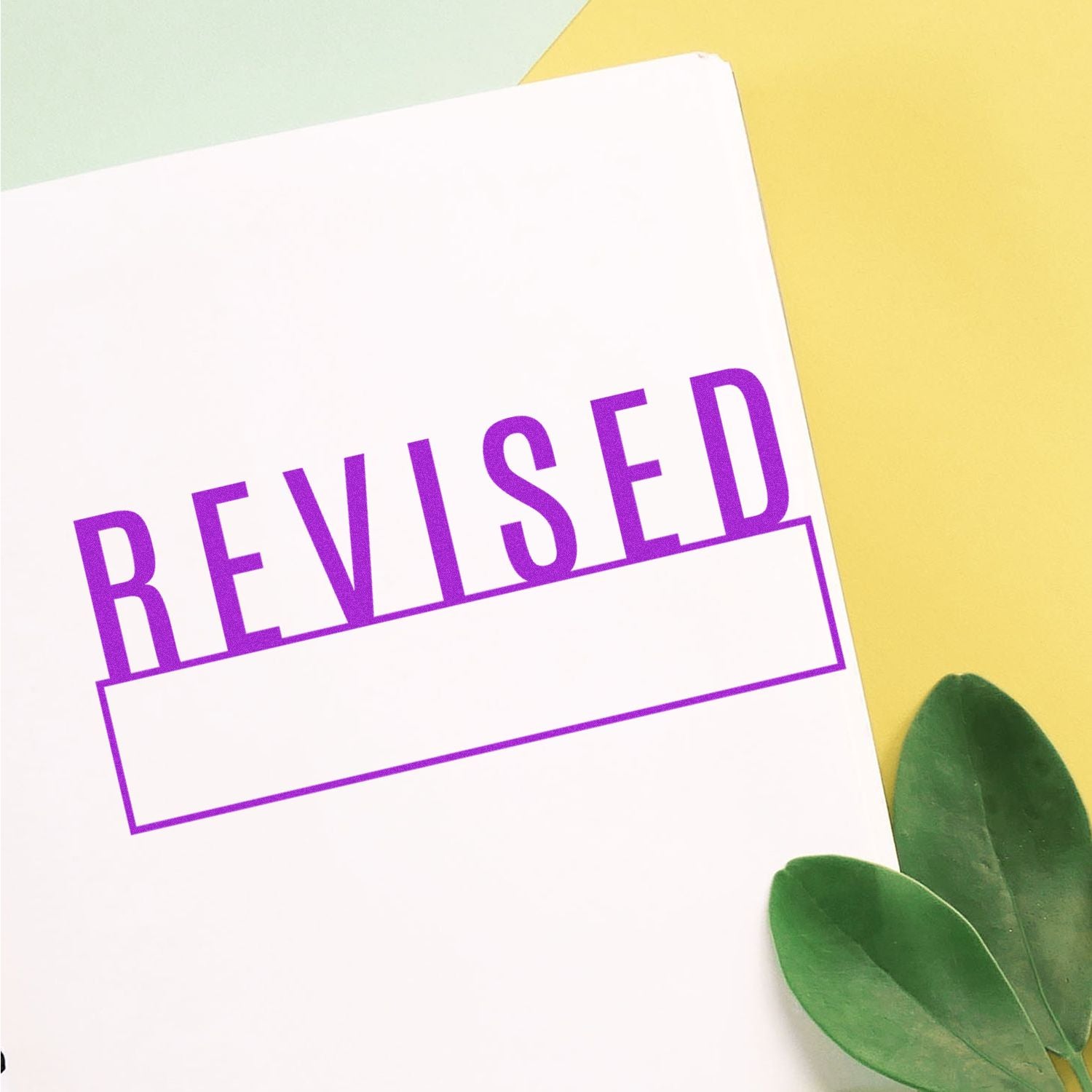 Purple REVISED text on white card with green leaves, indicating an edited document update for quality review and approval process.