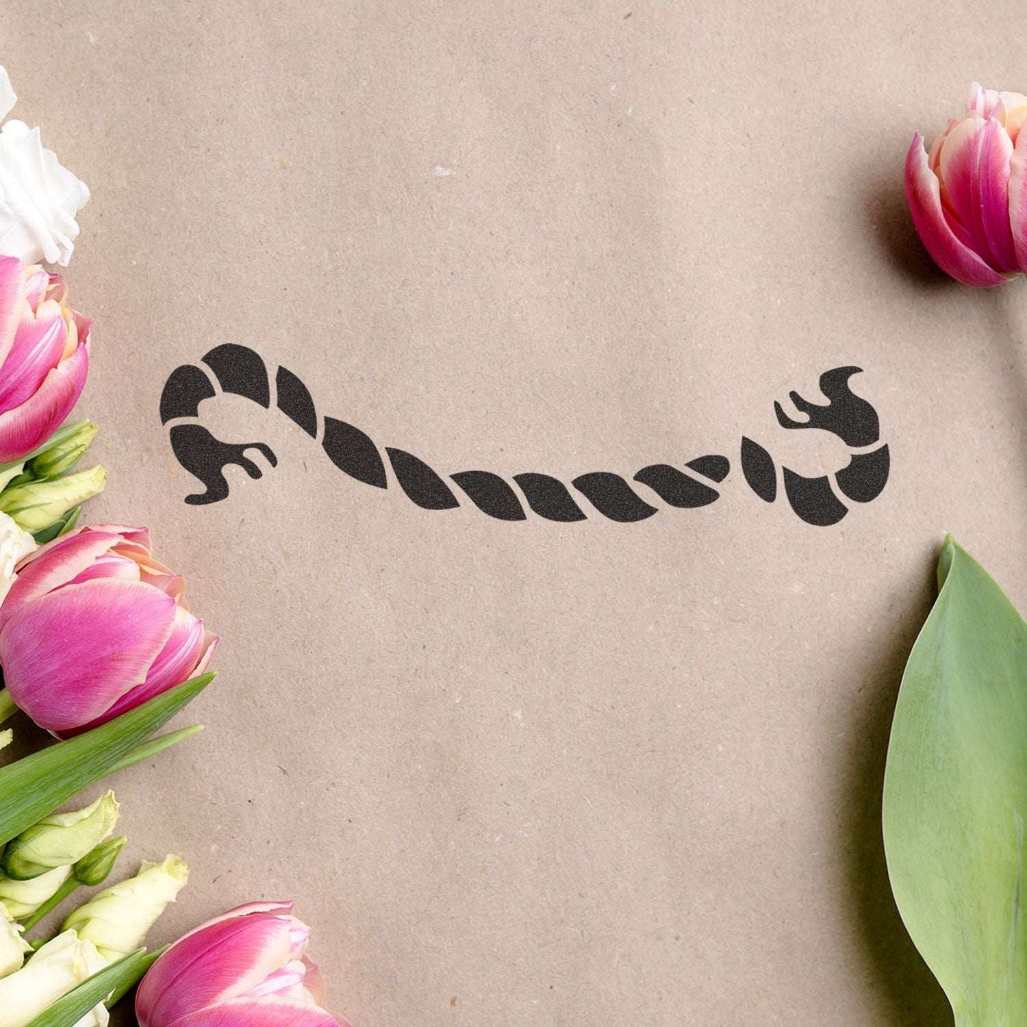Pink tulips framing a black Scorpio zodiac symbol on kraft paper background
