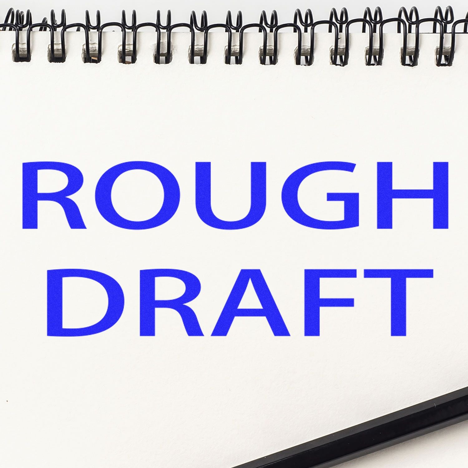Spiral notebook with ROUGH DRAFT in bold blue text on a white page.