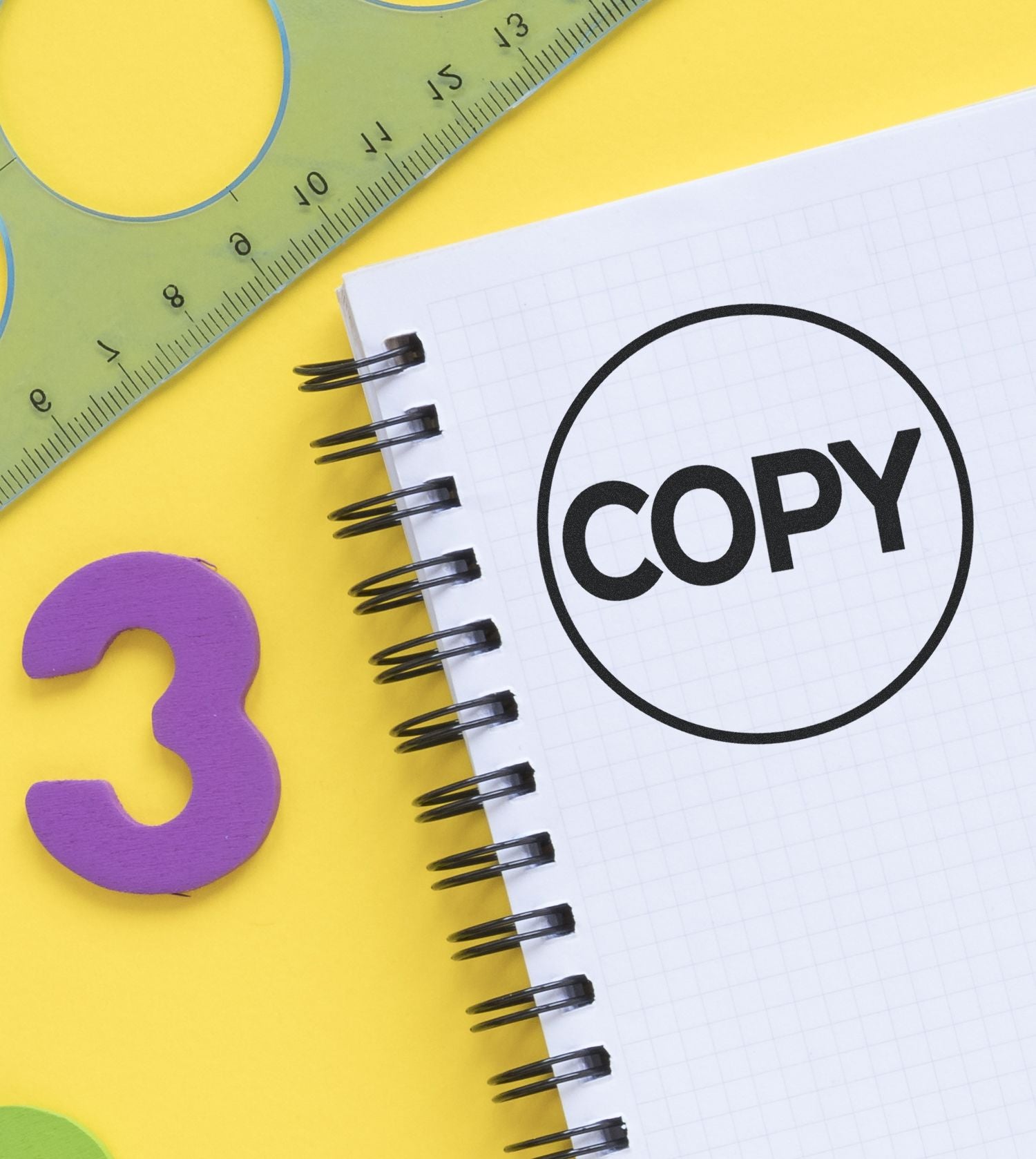 Close-up of notebook with COPY text, ruler, and number 3 on yellow background, school supplies concept.