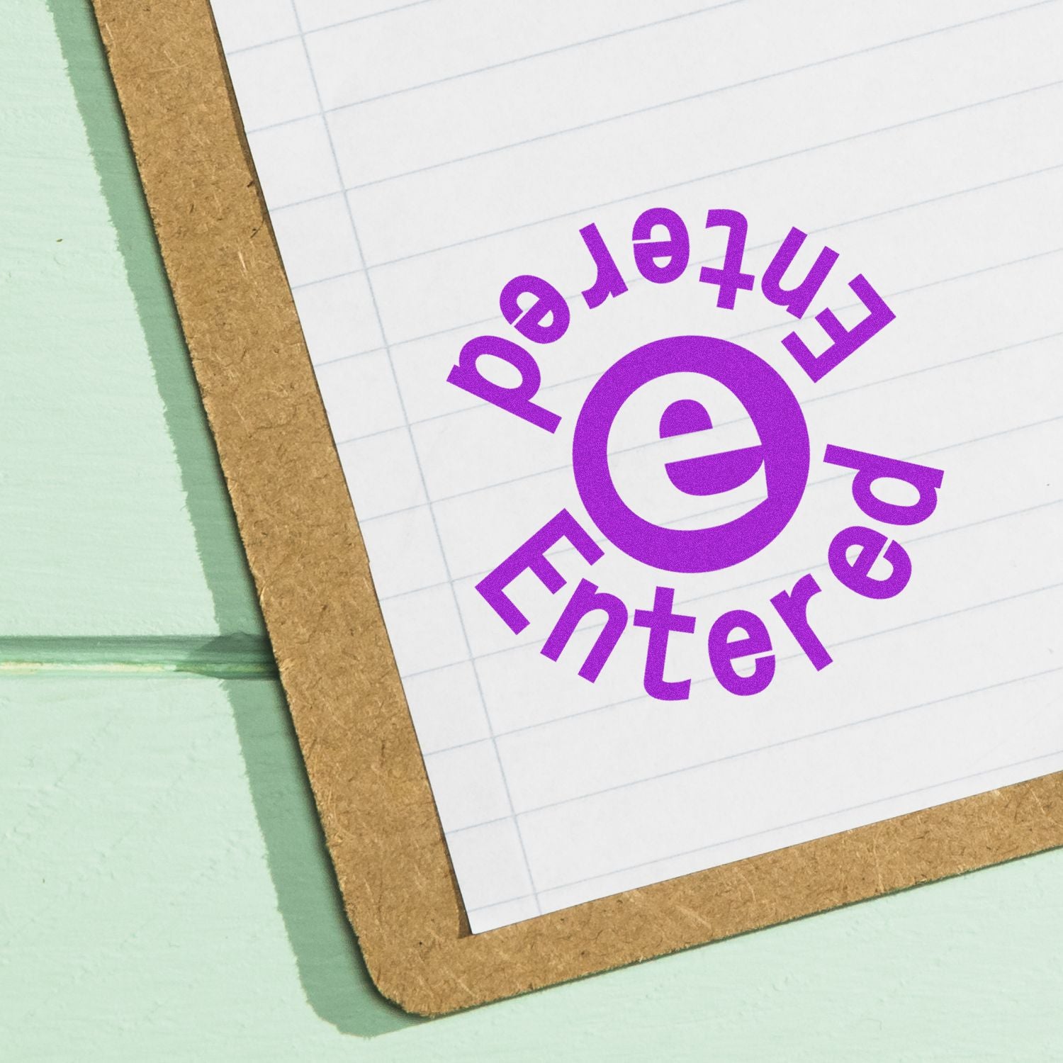 Close-up of a notebook page with a purple Enter icon and text on lined paper.