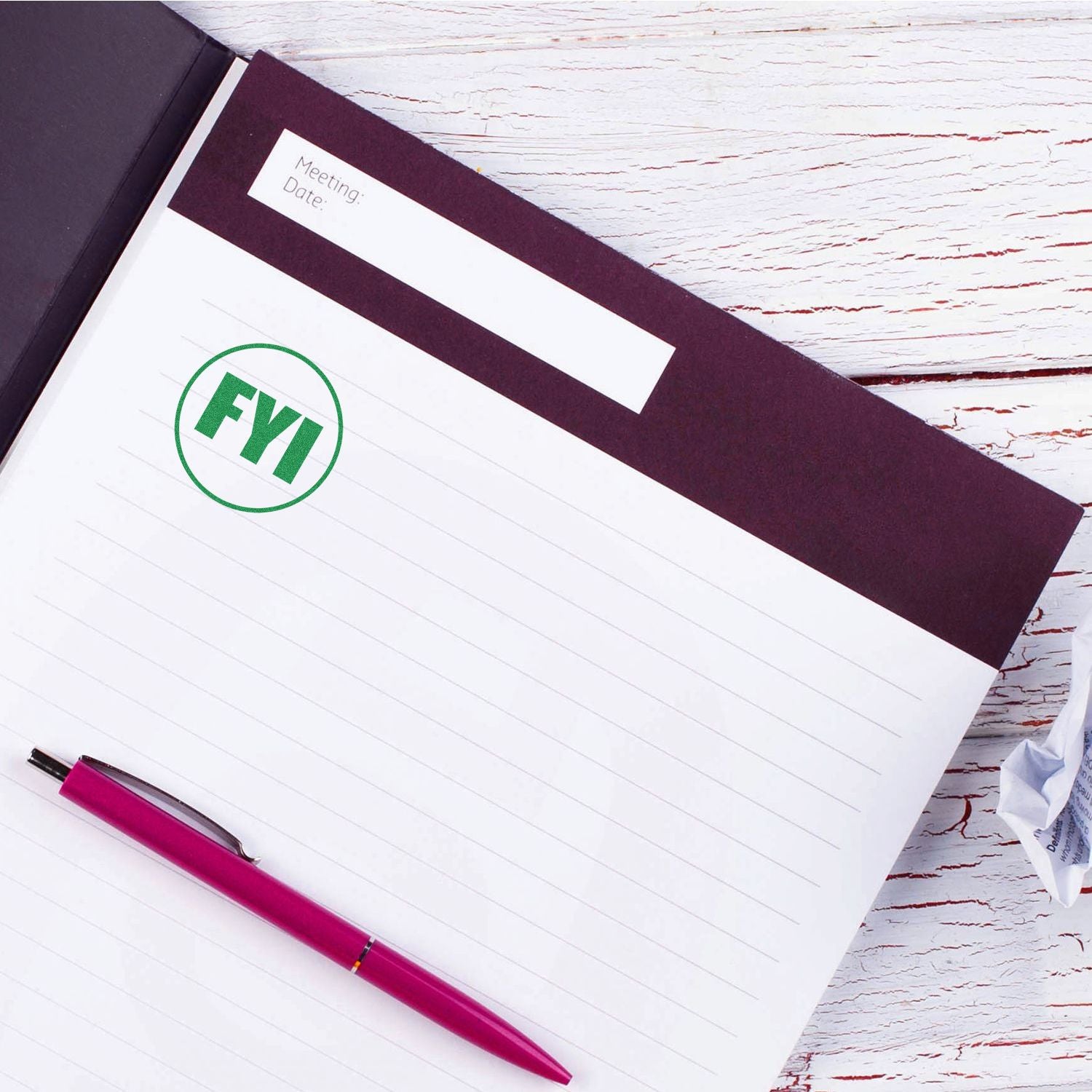 FYI meeting notes clipboard with pink pen on white wooden desk