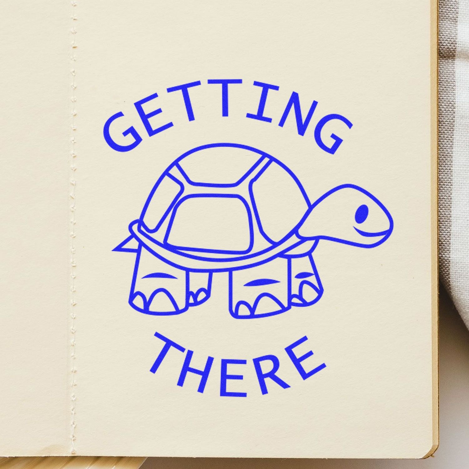 Blue turtle illustration with Getting There text on a cream notebook page, motivational and cute design.