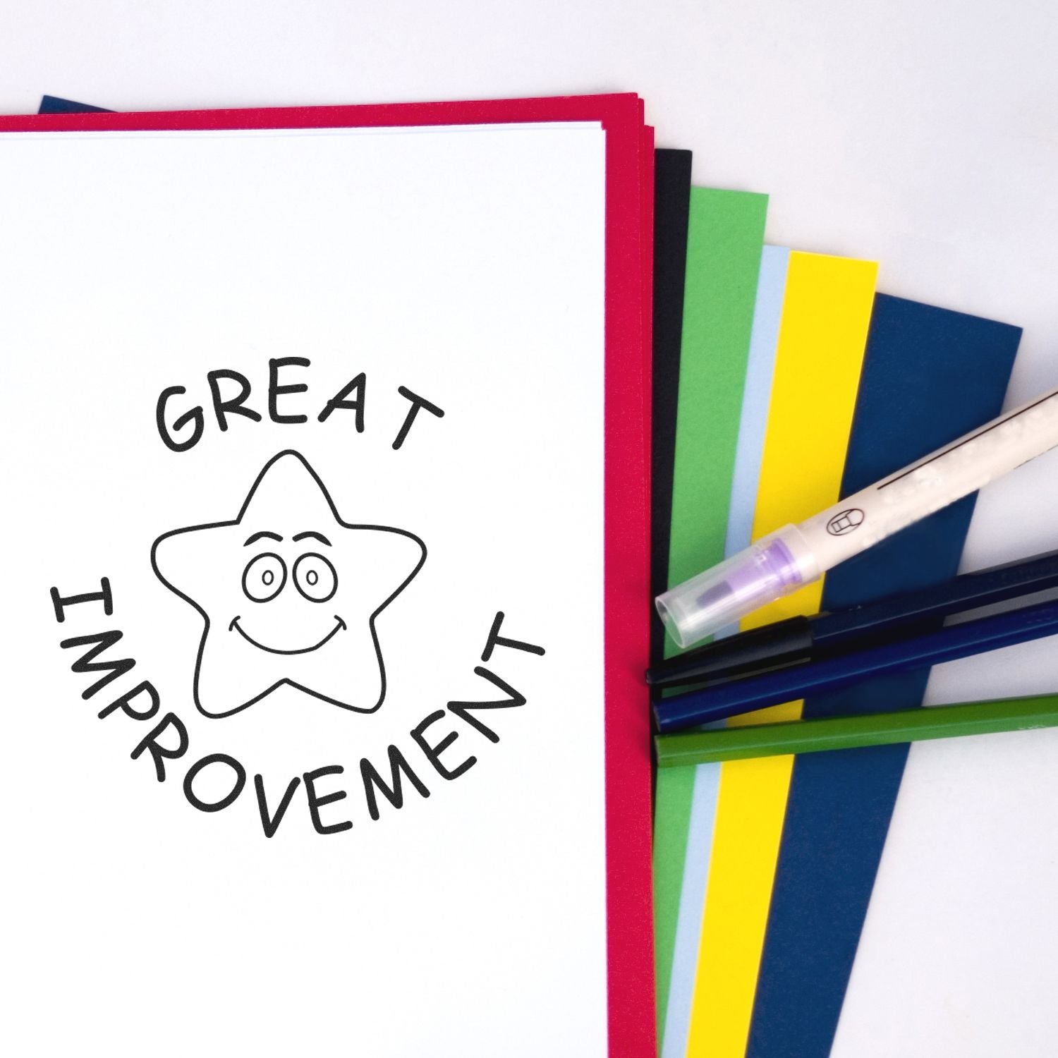 Great improvement notebook with smiling star, colorful folders, and pens on a white background.