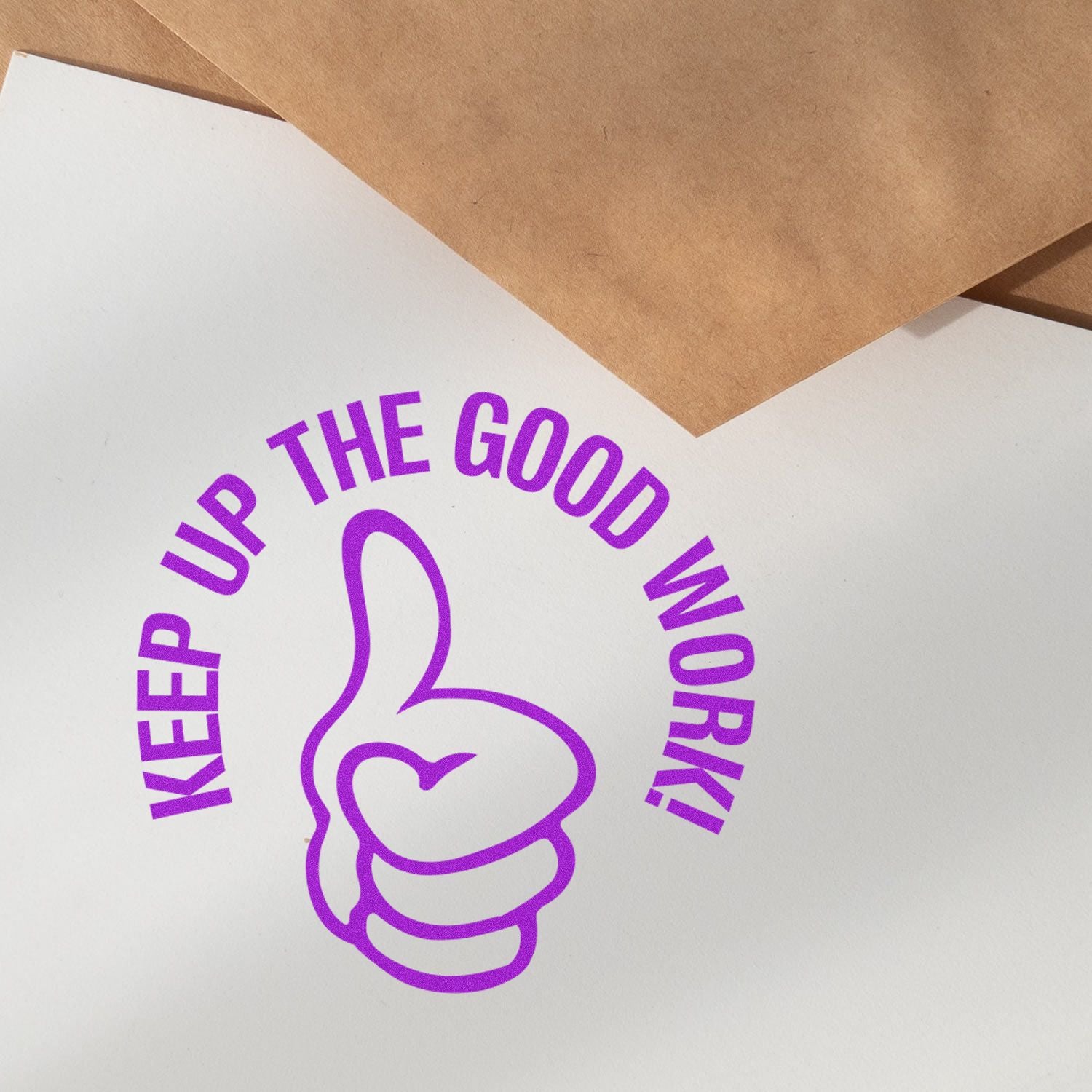 Purple Keep Up the Good Work motivational sticker with thumbs-up icon on white paper and kraft envelopes.