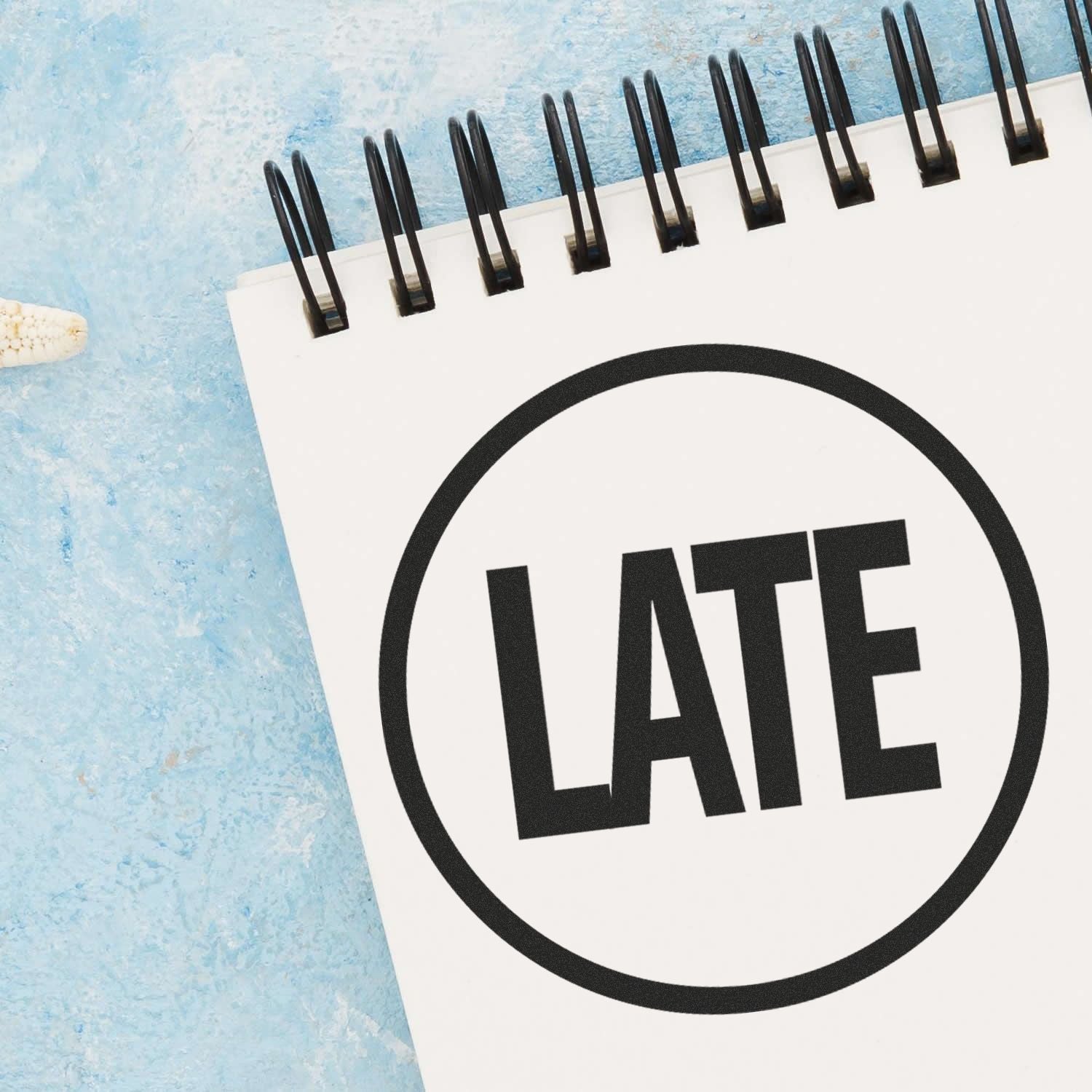 Notebook with bold LATE text, symbolizing missed deadline and time management reminder.