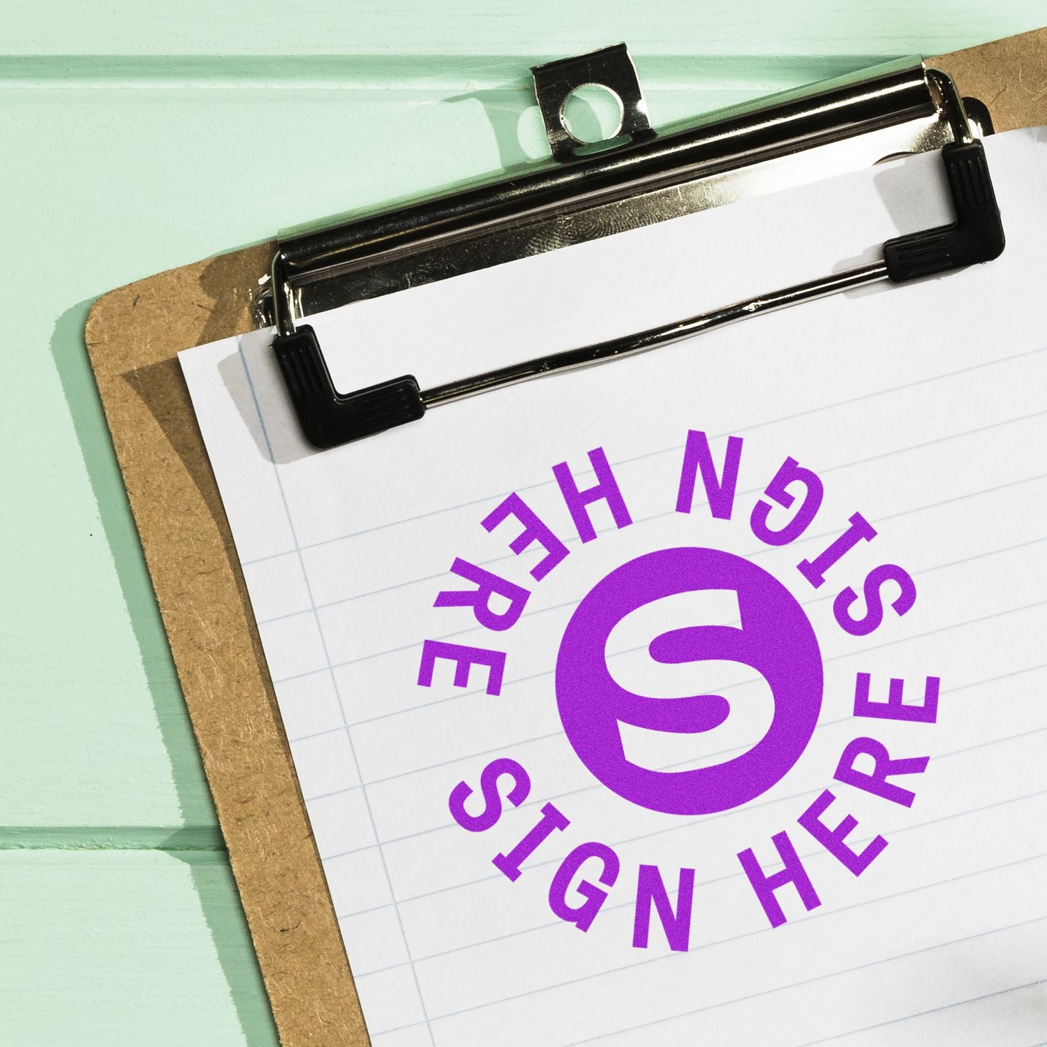 Close-up of clipboard with sign here document and purple signature icon on paper background