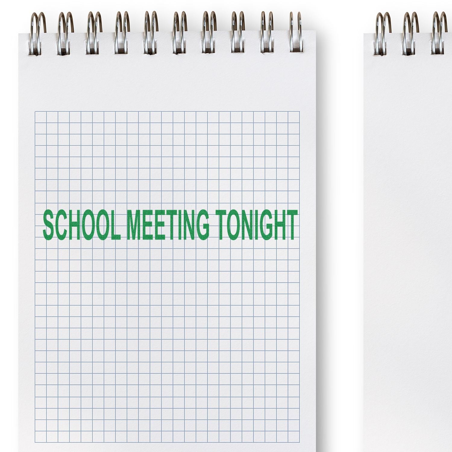 Spiral notebook with graph paper and School Meeting Tonight text, school announcement concept on a blank note page.