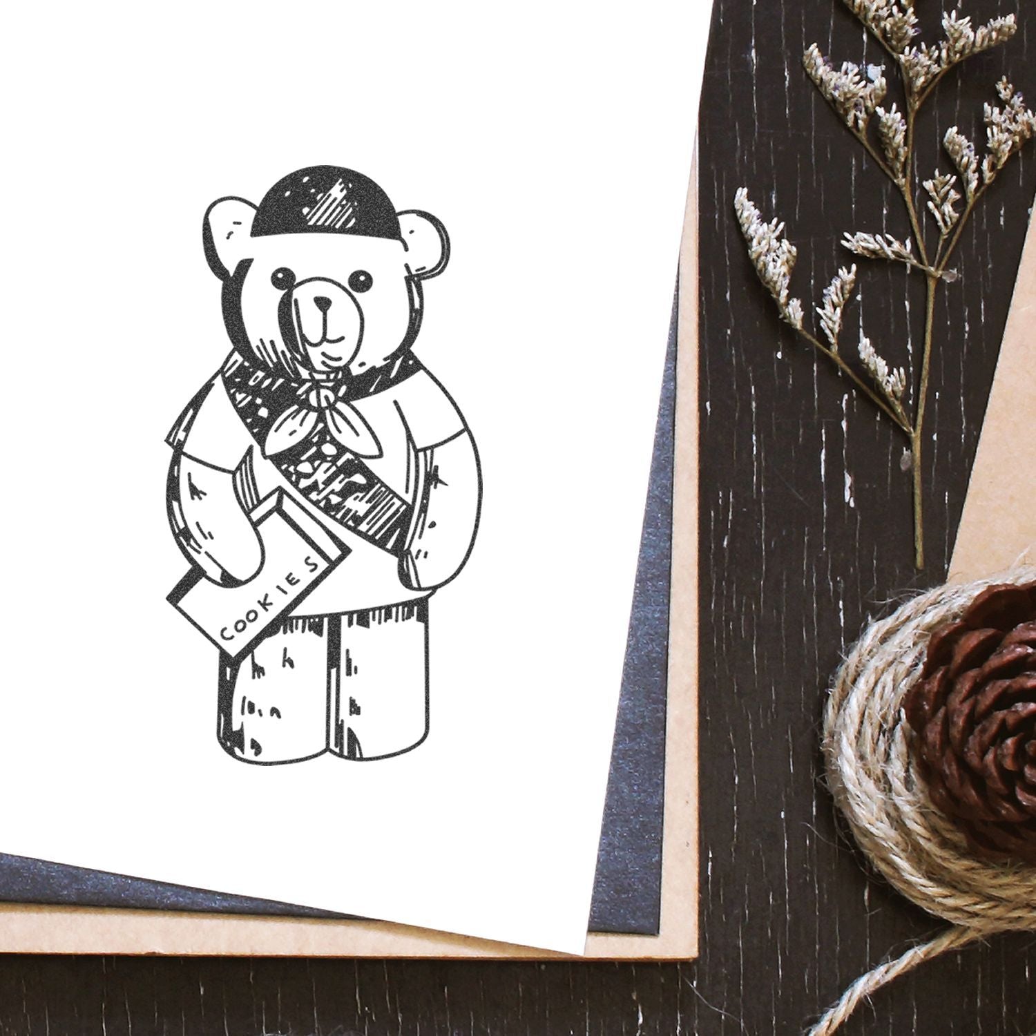Cute bear cookies illustration on handmade greeting card with rustic dried flowers and pinecone decor.