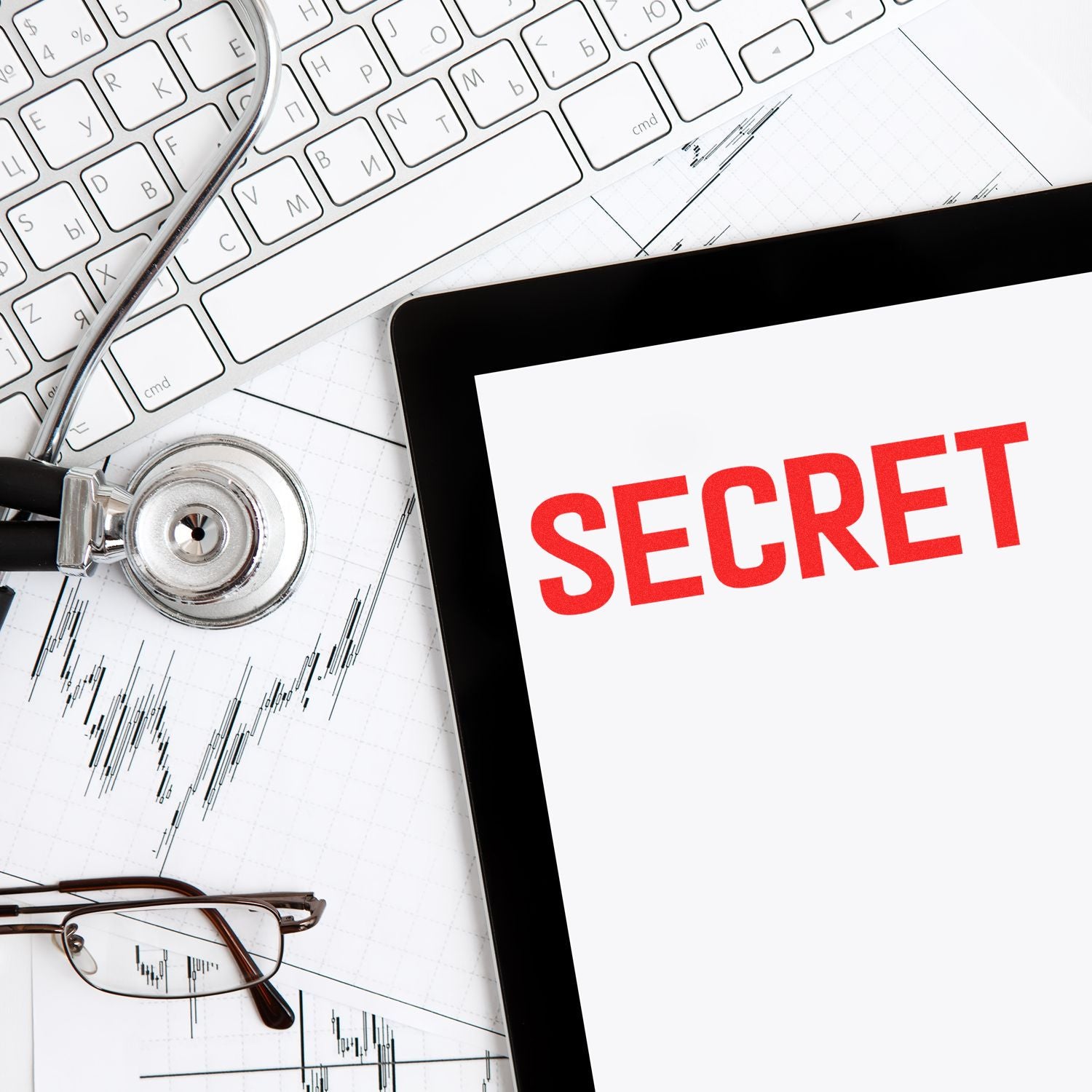 Stethoscope, keyboard, and tablet displaying SECRET over financial charts, symbolizing confidential data security.