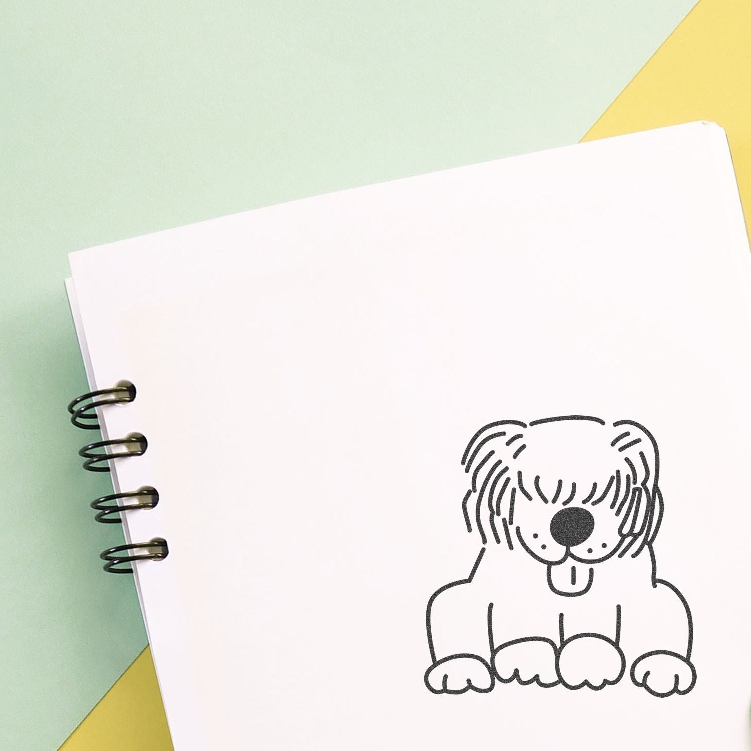 Cute dog illustration on a spiral notebook with pastel green and yellow background, ideal for pet-themed stationery and design.
