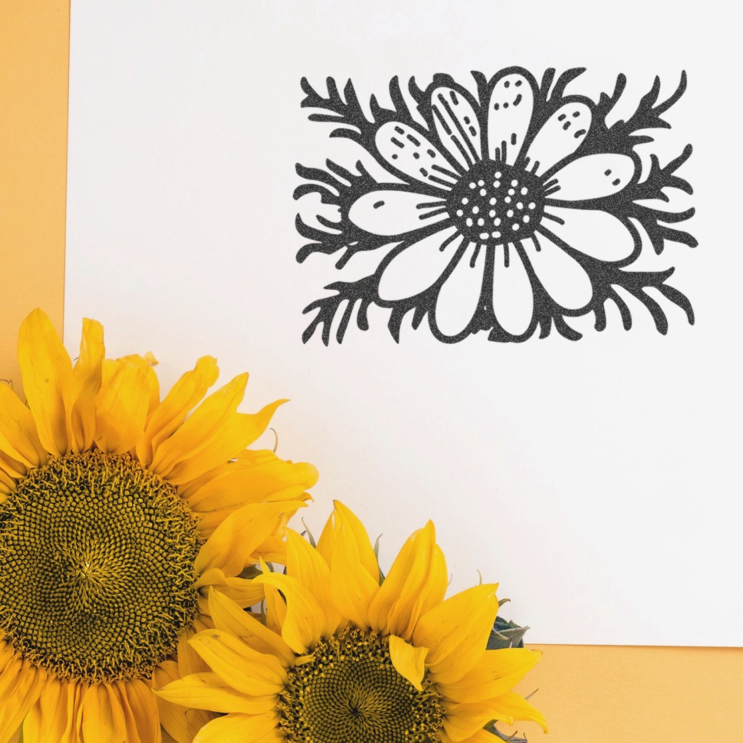 Bright yellow sunflowers with a black floral illustration on white paper against a soft yellow background.