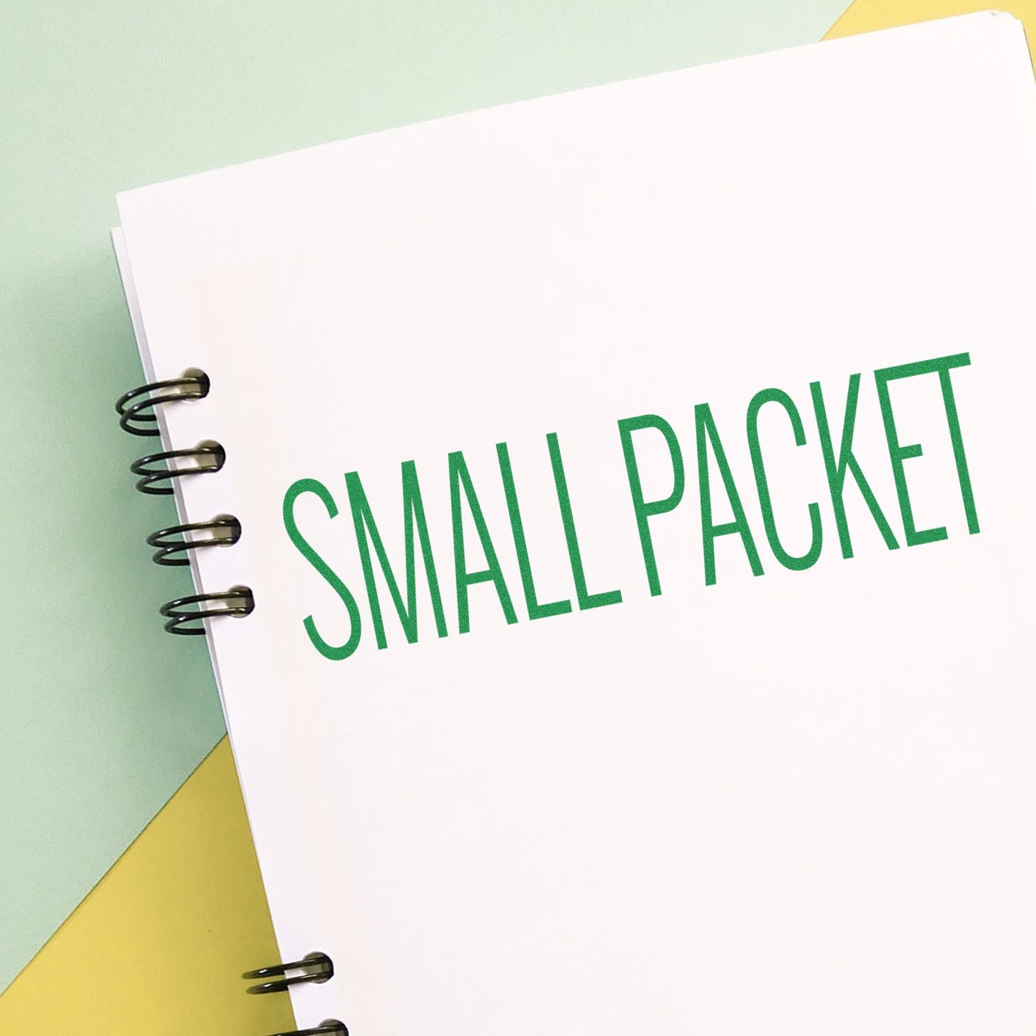 Small packet spiral notebook with green text on a pastel background