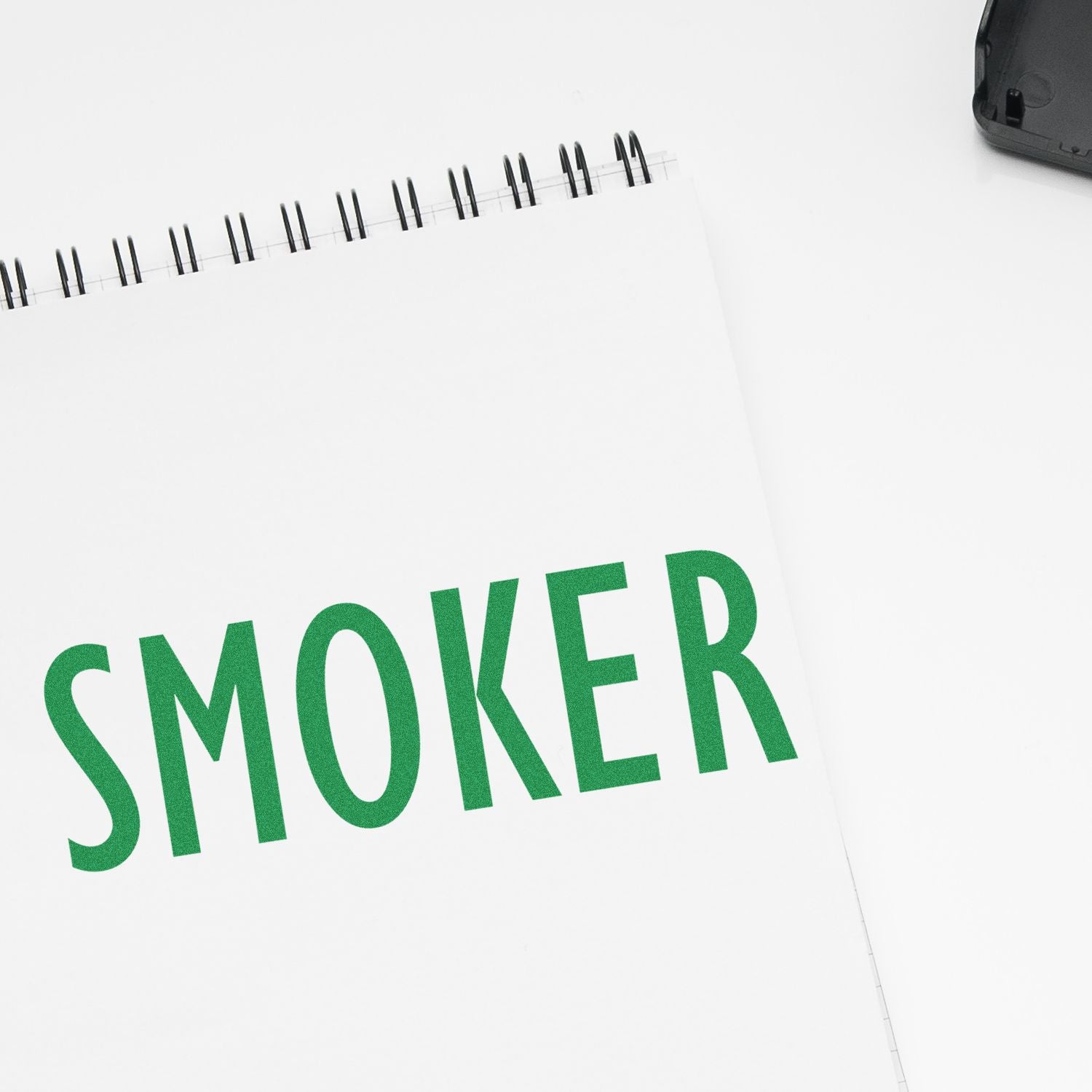 SMOKER printed on a white spiral notebook page, representing smoking status and quitting awareness.
