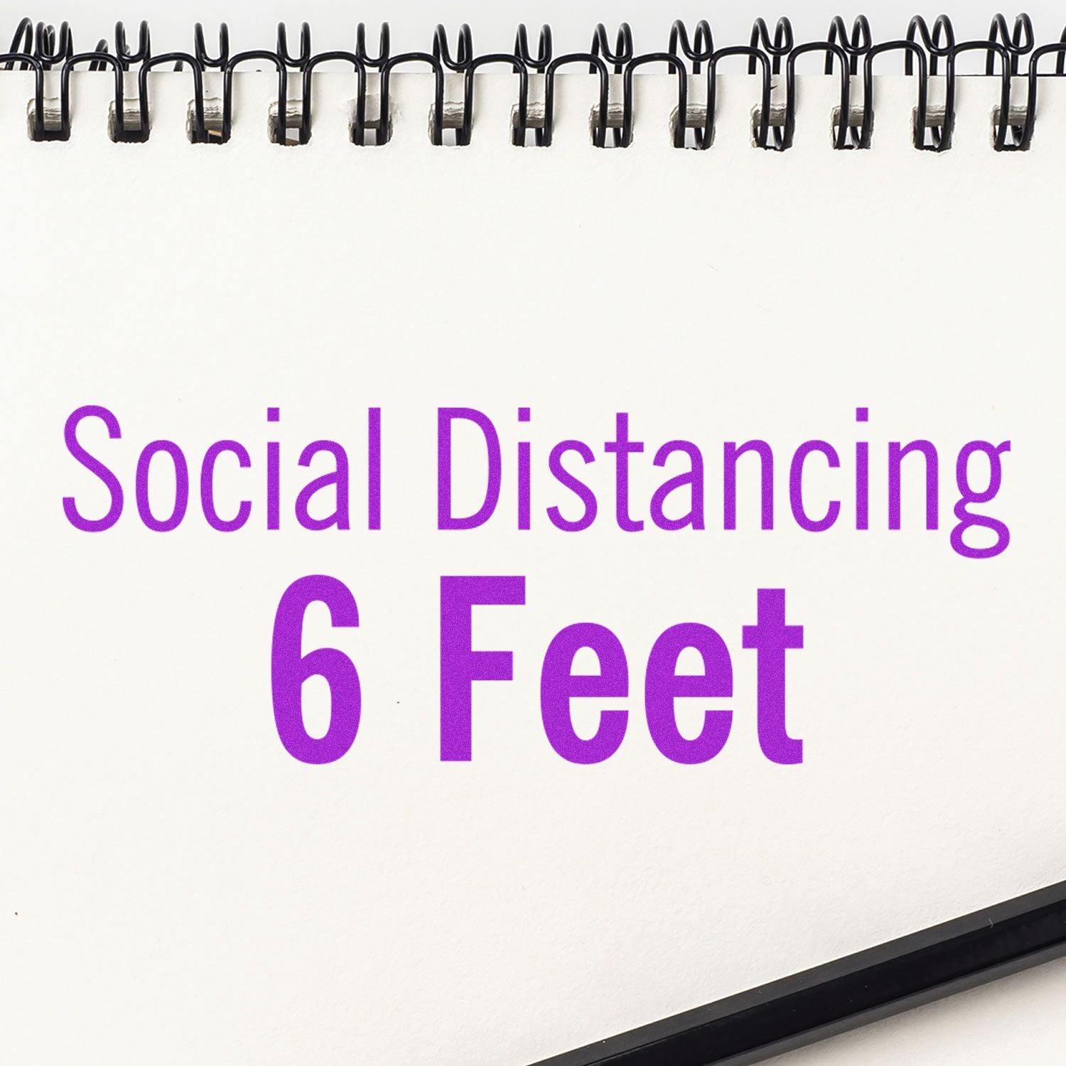 Spiral notebook page with Social Distancing 6 Feet text on a white background.