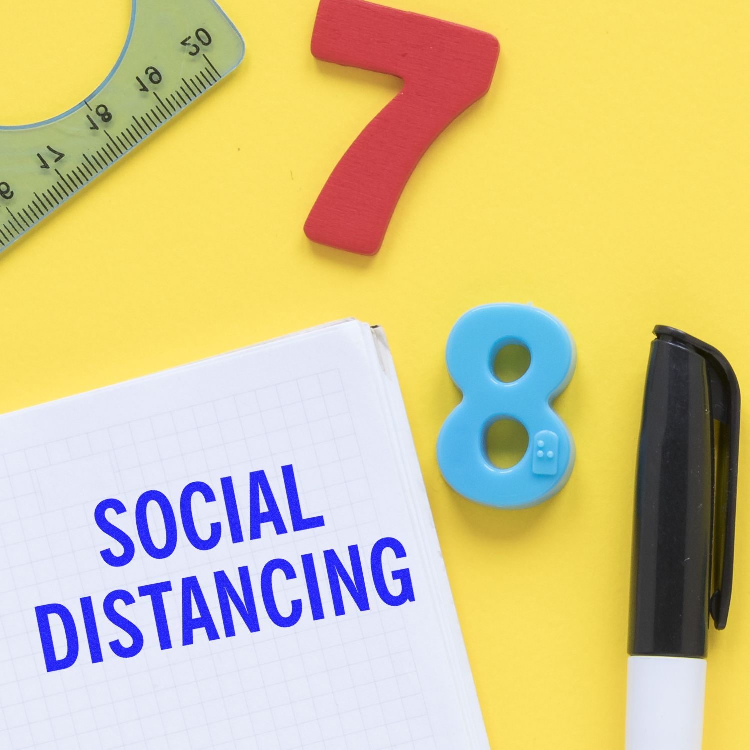 Social distancing concept with notebook, numbers 7 and 8, ruler, and marker on yellow background.