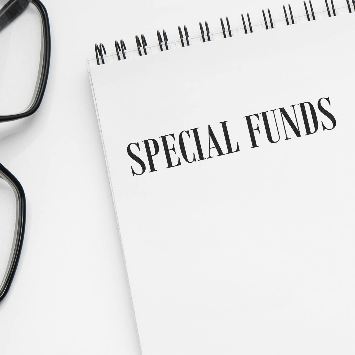 Notebook page labeled Special Funds with glasses, illustrating finance budgeting and allocation of special-purpose funds.