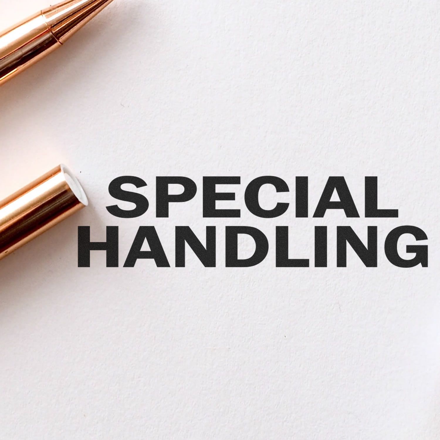 Special handling label on white paper with copper pen, indicating fragile or priority shipping instructions.