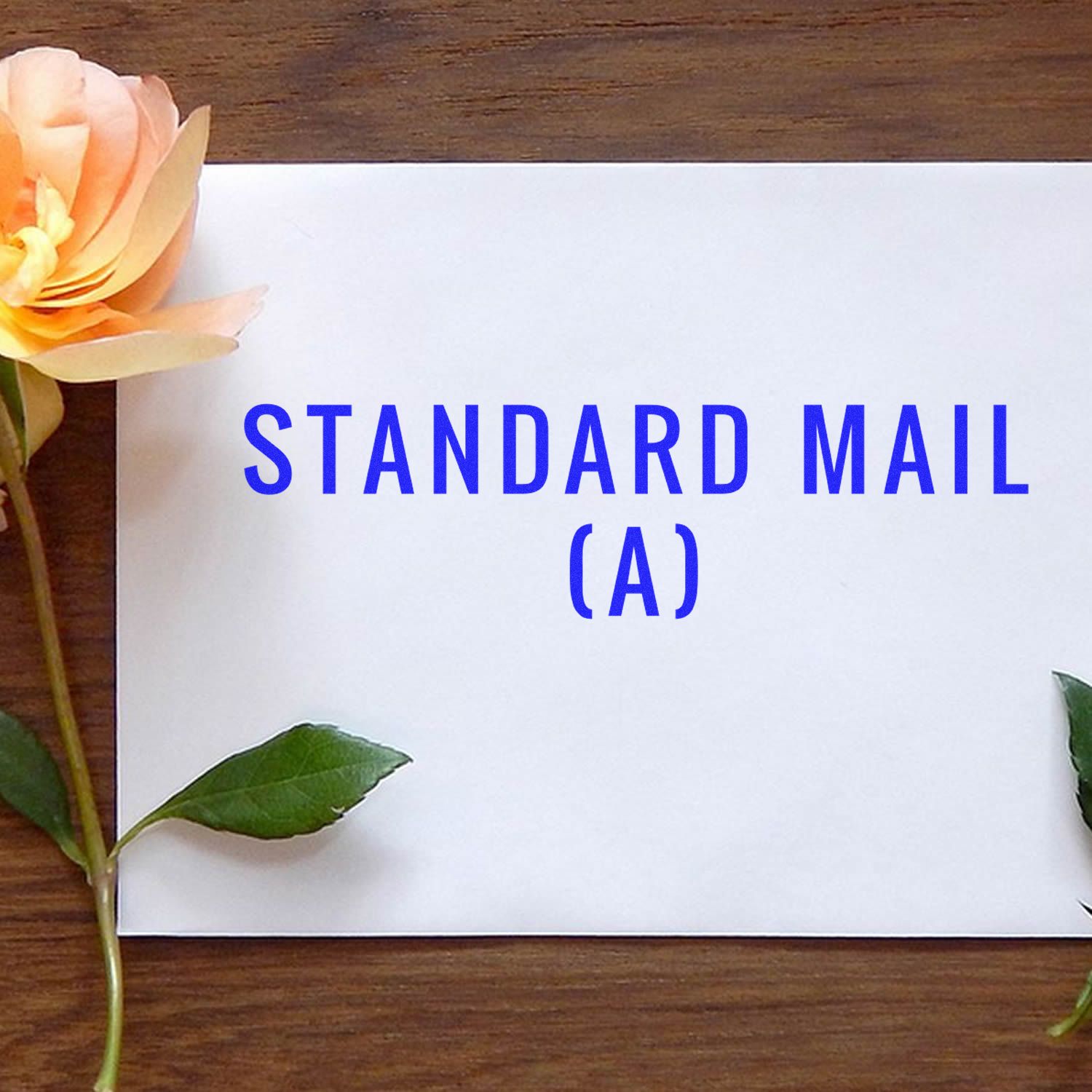 Standard mail (A) on stationery with flowers and leaves on wooden desk, representing postal service delivery.