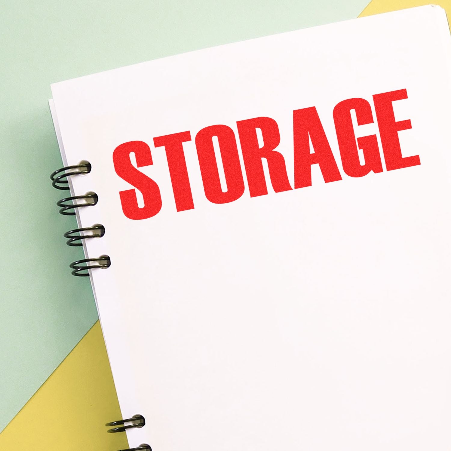 Notebook with bold red STORAGE text on a spiral-bound cover, representing file and data storage concept.