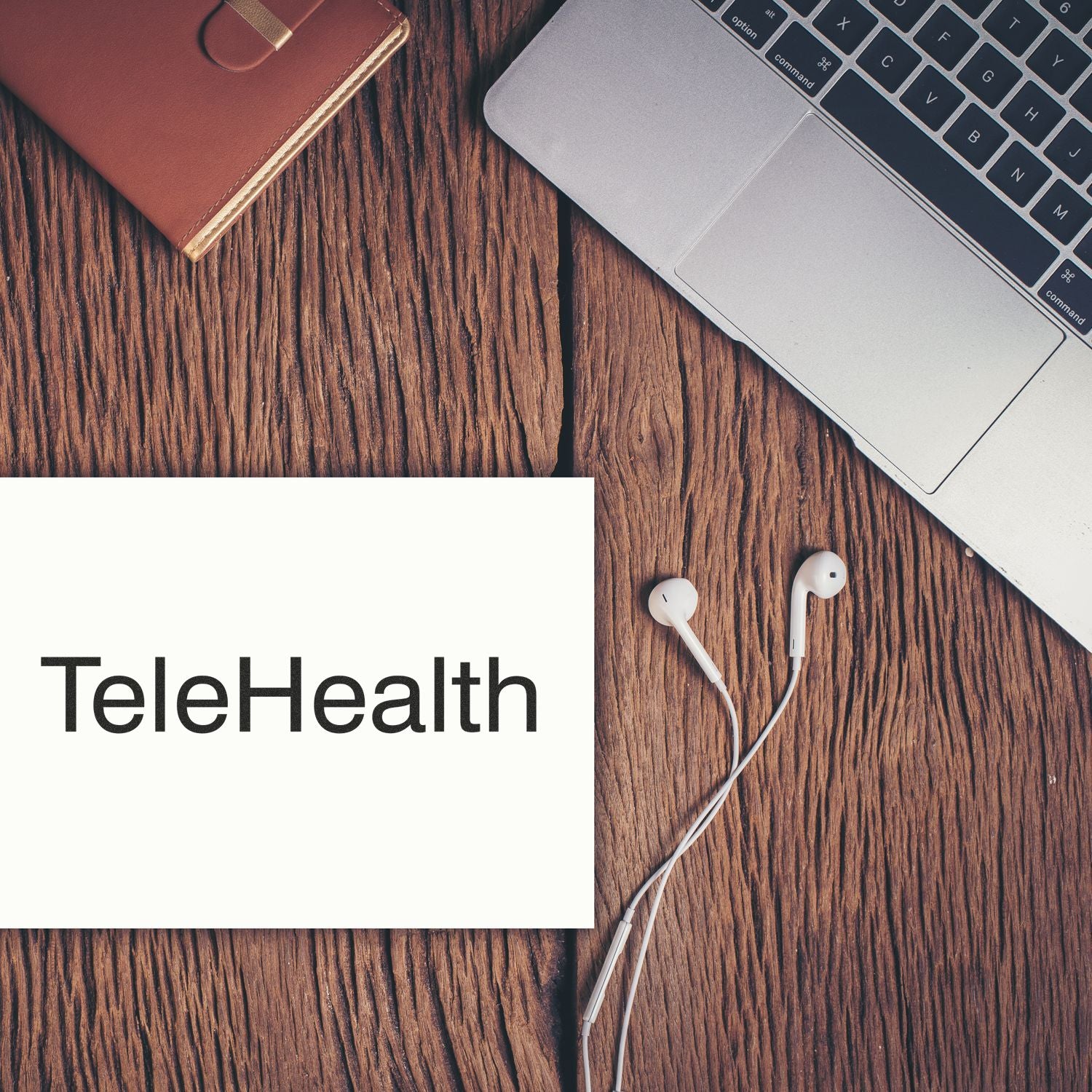 Telehealth concept: laptop and white earbuds beside a wallet on a desk, featuring TeleHealth text for remote online medical care.