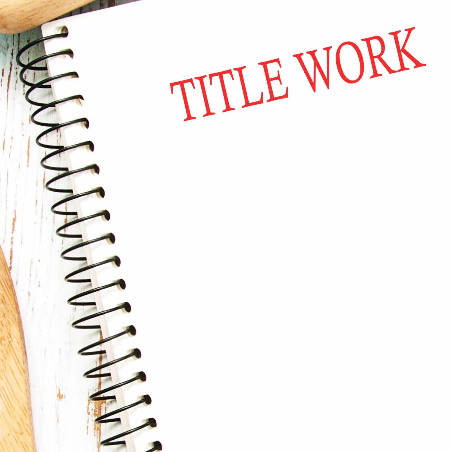 Spiral notebook page with TITLE WORK text for writing or document title design concept