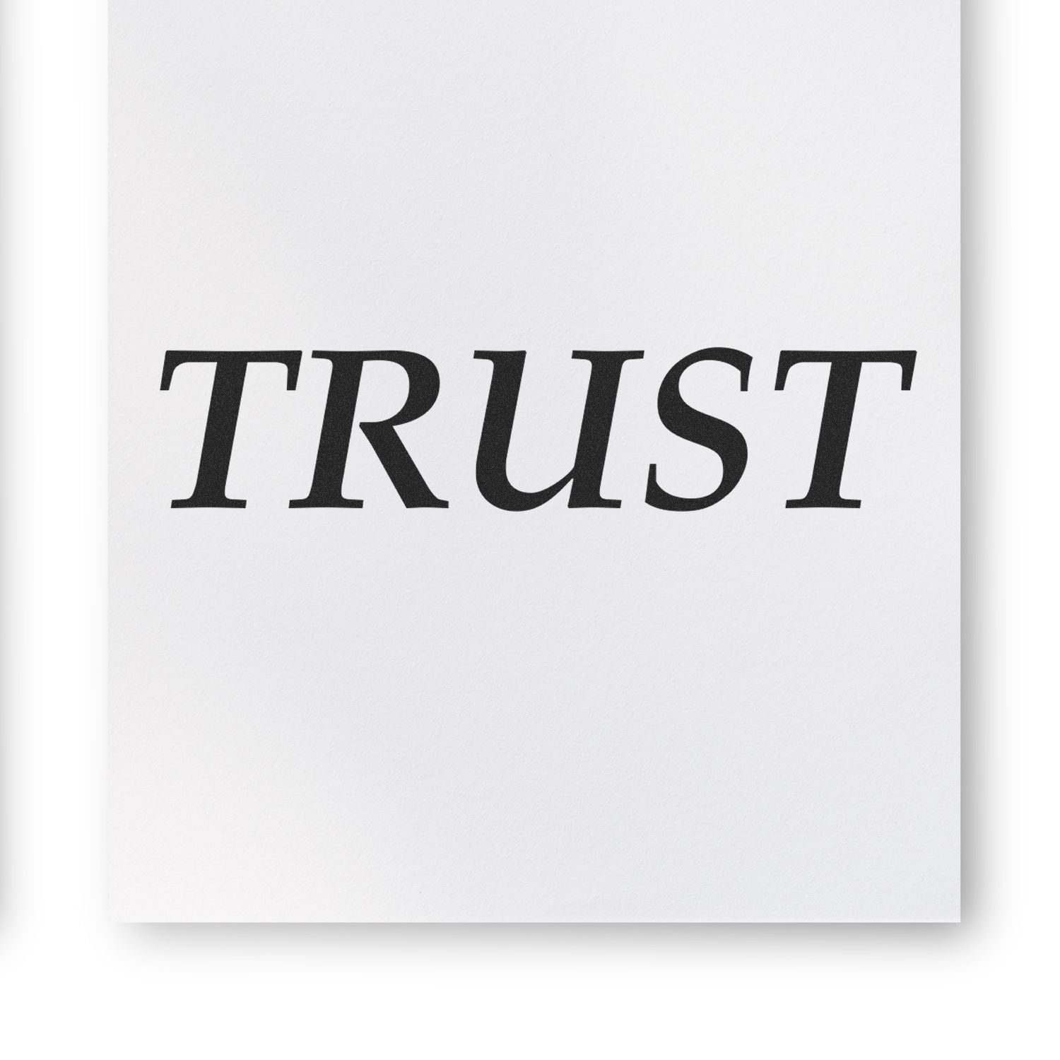 Black serif word TRUST printed on white paper, minimal inspirational typography design.
