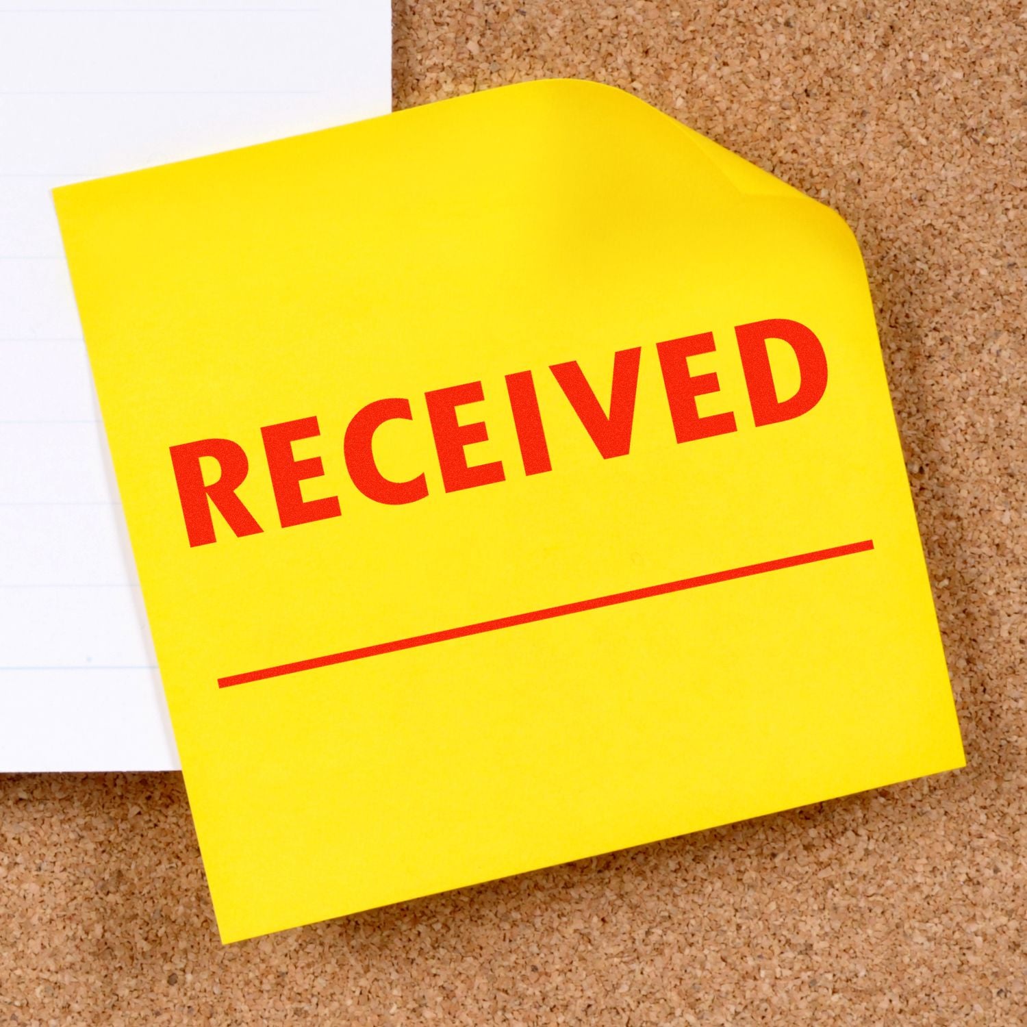 Yellow RECEIVED sticky note on a cork board with paper background, office document received stamp concept.