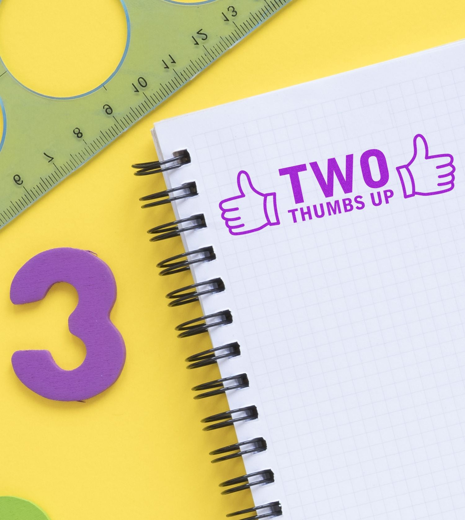 Colorful school supplies with notebook reading Two Thumbs Up, ruler, and purple number 3 on yellow background.