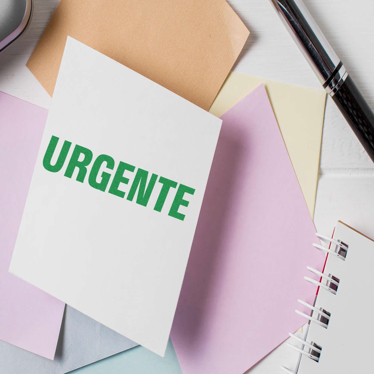Urgent reminder on a notebook with colorful sticky notes and pen on a desk.