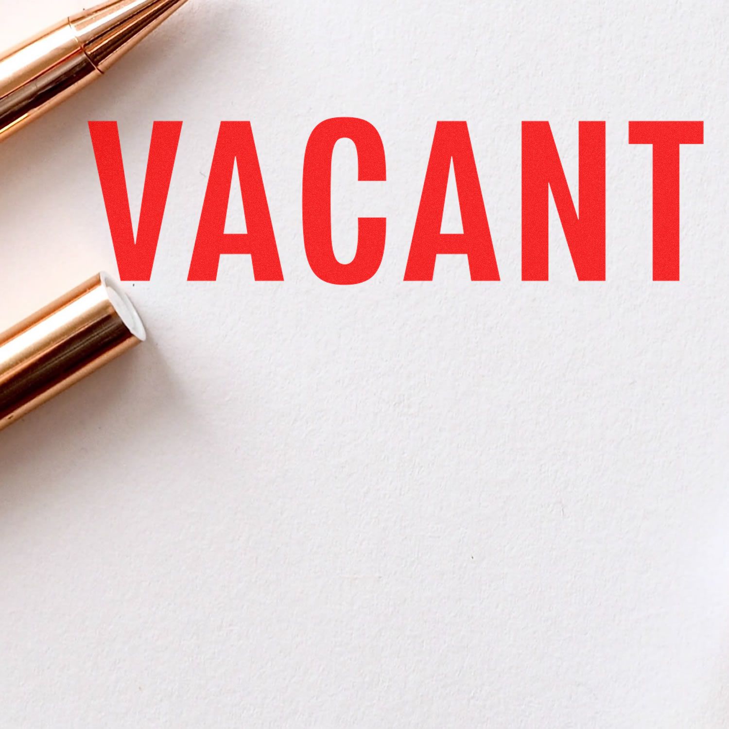 Red VACANT sign on a white background with gold makeup brushes, concept for empty or available space.