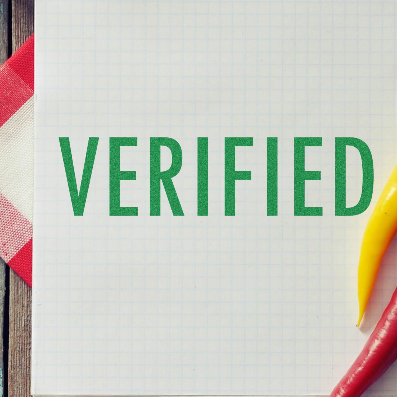 VERIFIED stamp in green on graph paper with pencil, representing quality assurance and confirmation