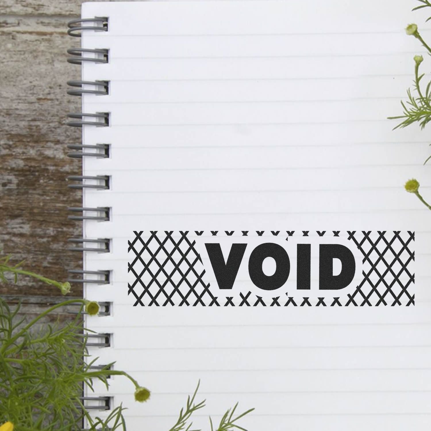 Blank white spiral notebook with bold VOID label sticker on rustic wooden background and greenery accents