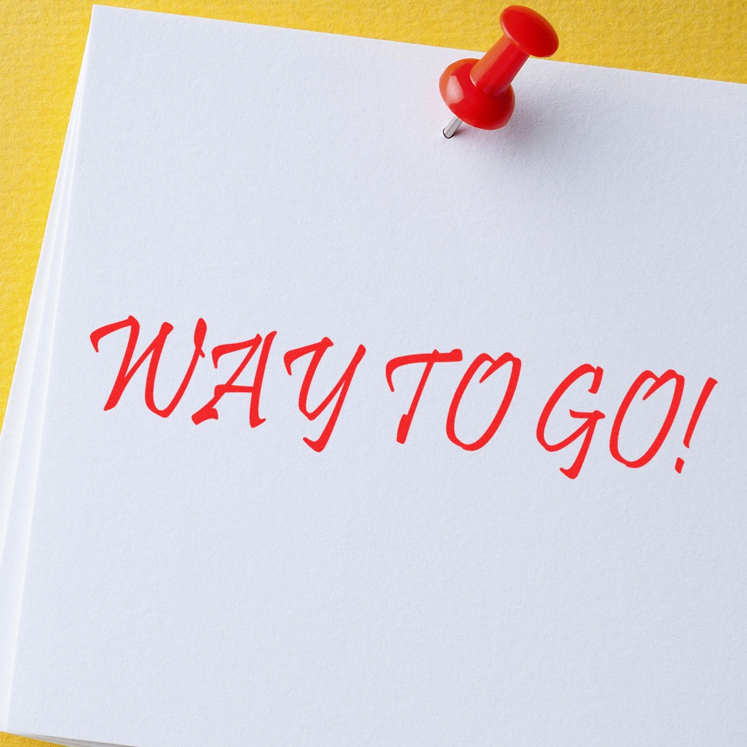 Red push pin holding a white paper note with WAY TO GO! written in bold red letters on a yellow background.