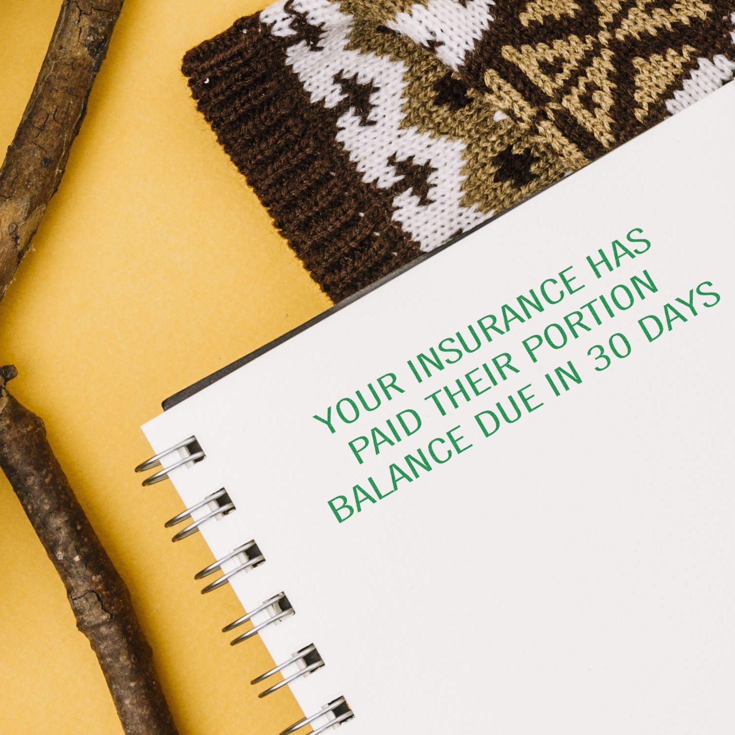 Notebook with health insurance balance due reminder on yellow background, reading Your insurance has paid their portion, balance due in 30 days