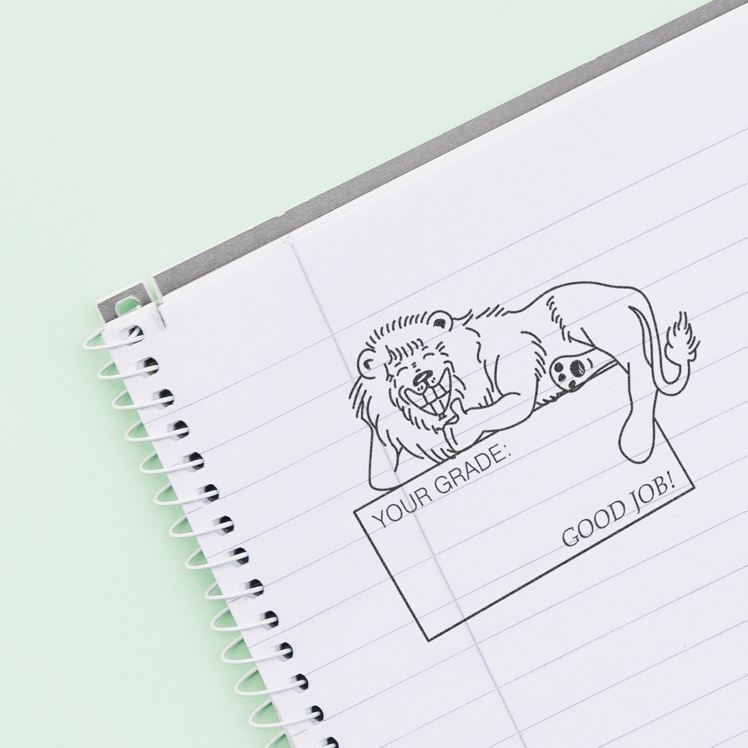 Spiral notebook with cute lion doodle and Your Grade: Good Job! stamp on lined paper.