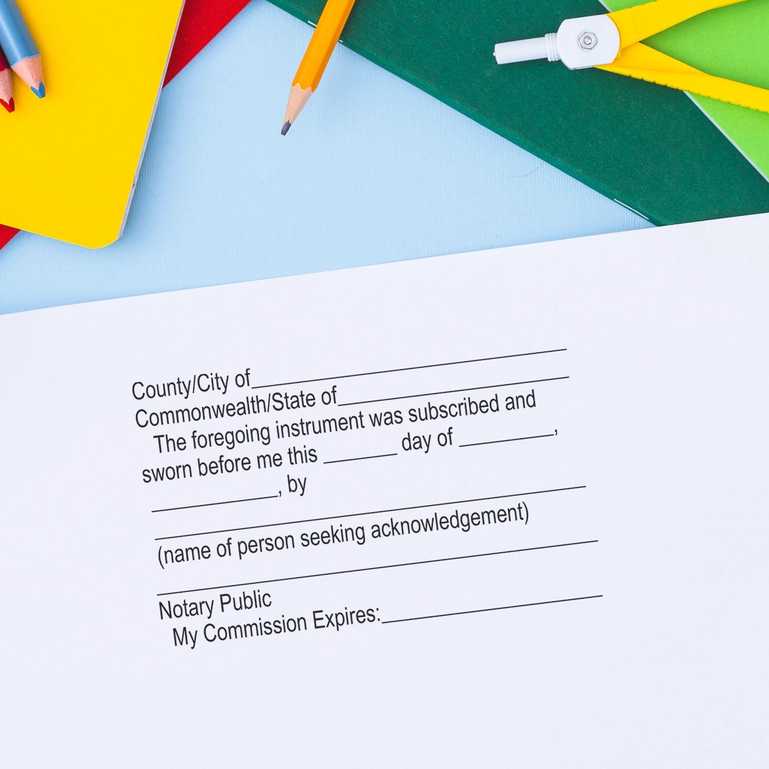 Colorful stationery with pencils above a notary public acknowledgement form and blank legal document.