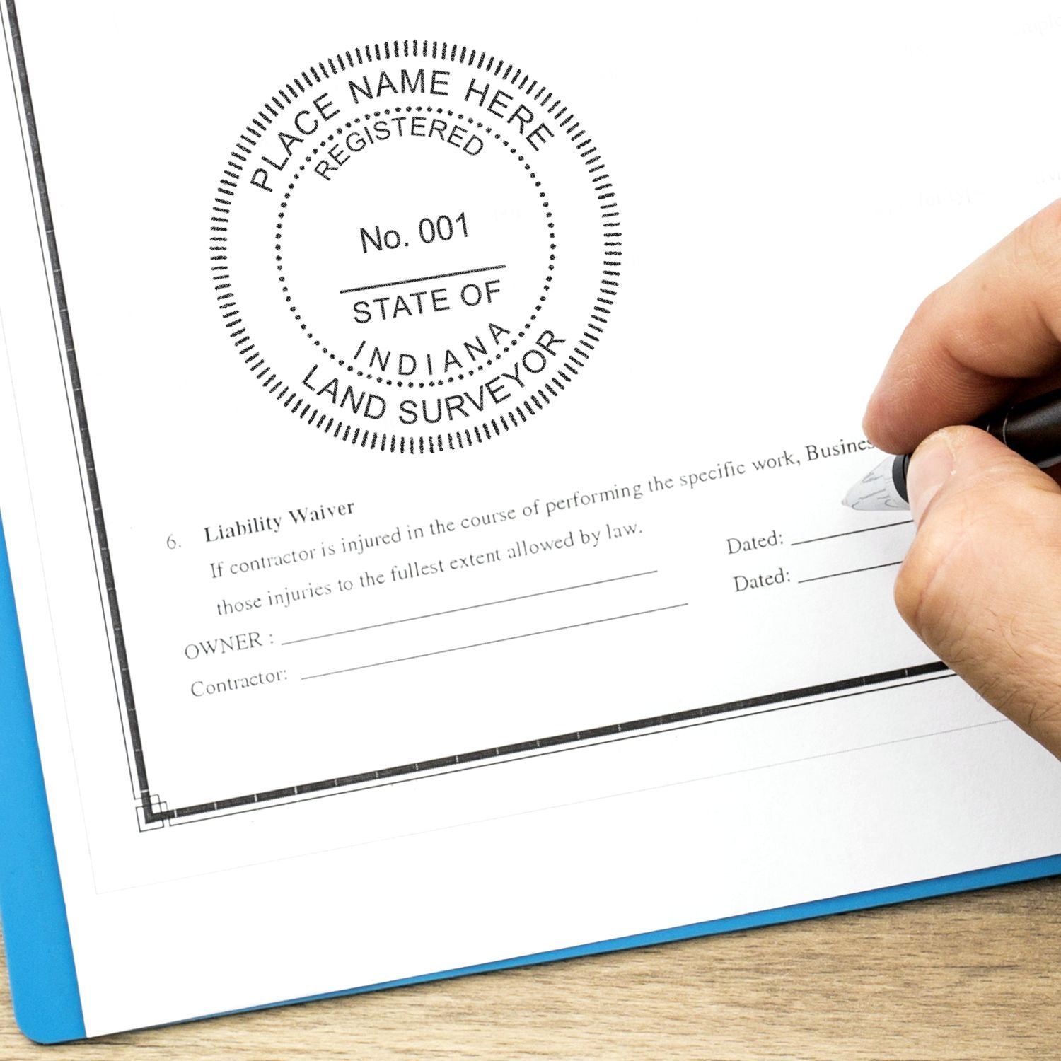 Hand signing a legal document with a State of Indiana land surveyor registered stamp and liability waiver form.