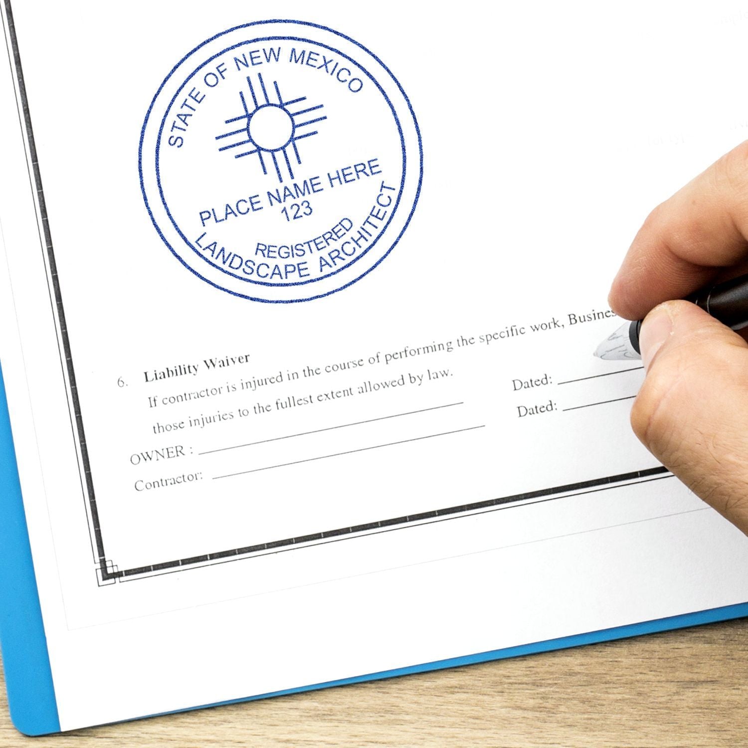 Hand signing landscape architect contract with State of New Mexico registered seal on a liability waiver document.