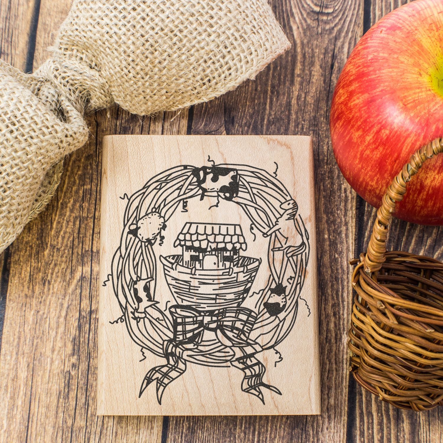 Rustic wooden apple stamp with farm basket design on a farmhouse-style wood background