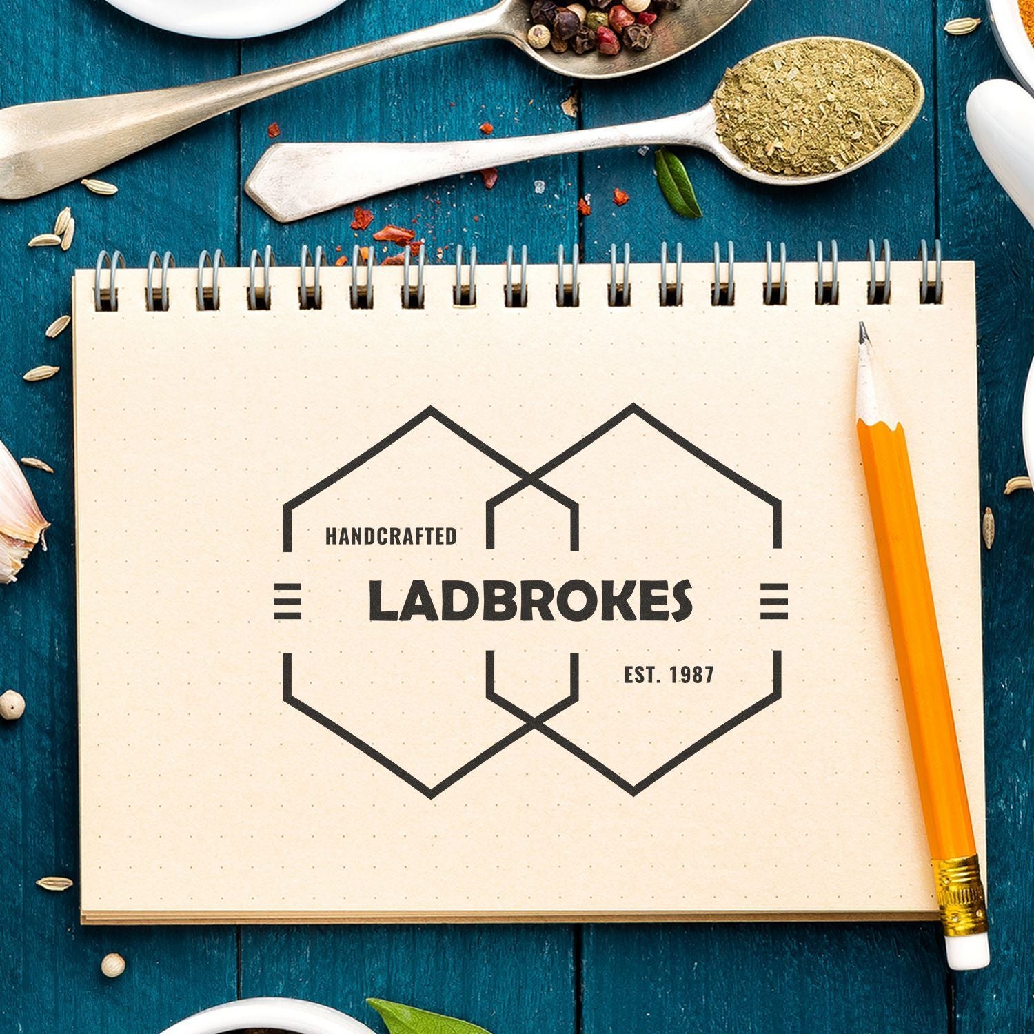 Handcrafted Ladbrokes Est. 1987 logo on a notepad with herbs and spices, promoting homemade seasoning and kitchen craft.