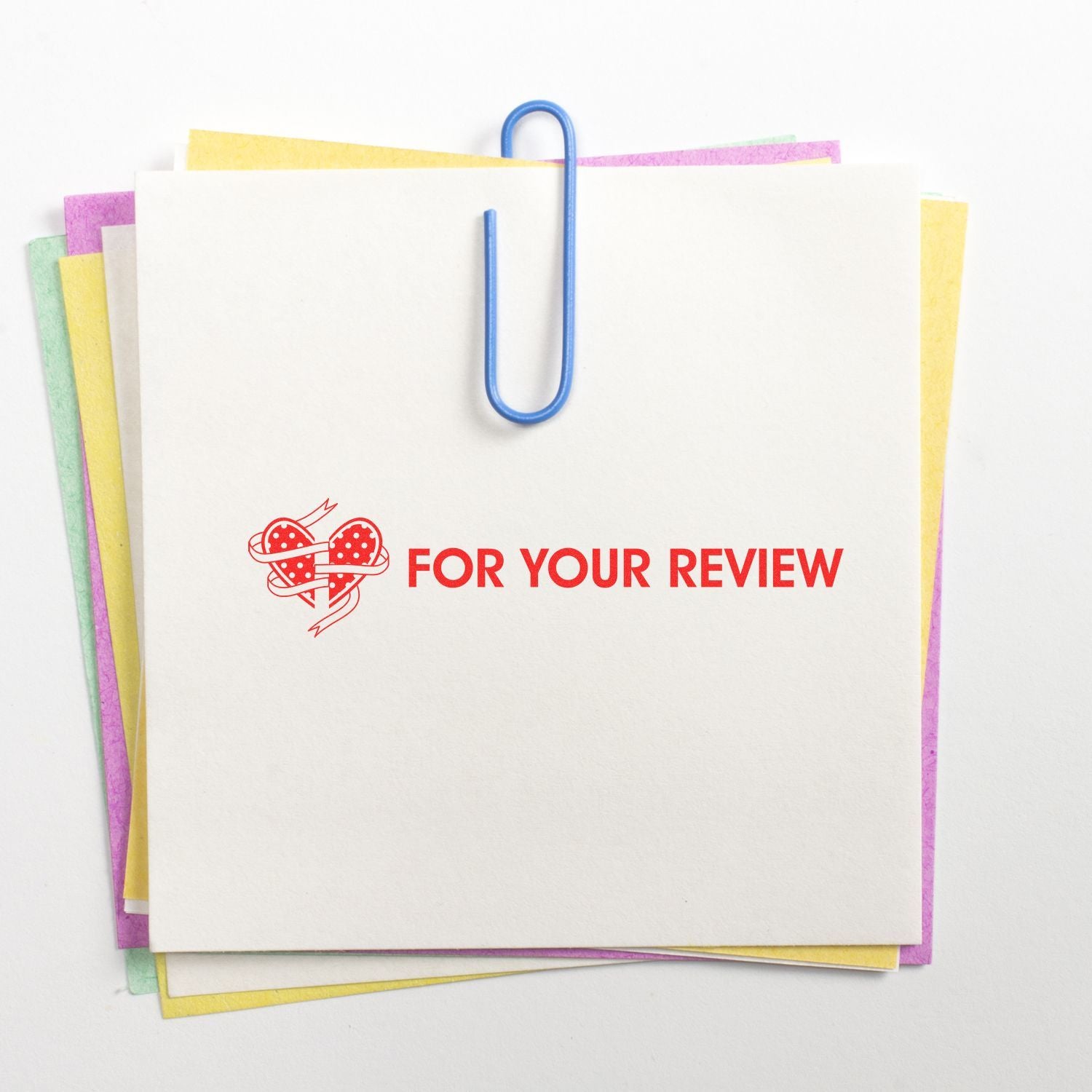 Stack of colorful paper notes with a blue paperclip and For Your Review stamp, office document review concept.