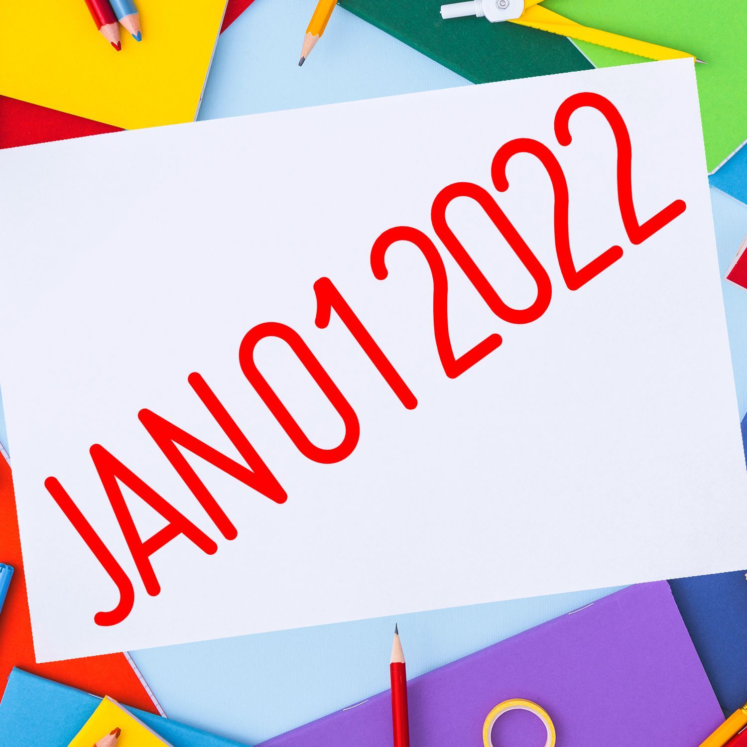 January 2022 text on white paper with colorful stationery and pencils background
