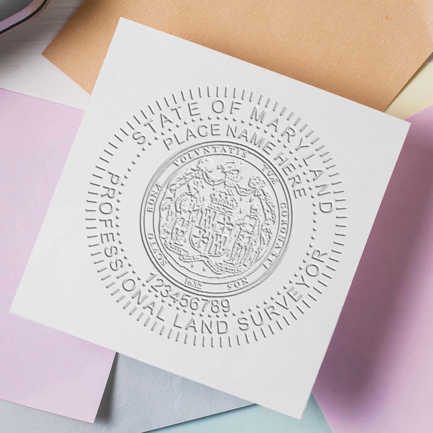Embossed State of Maryland Professional Land Surveyor seal on white paper with pastel stationery background.