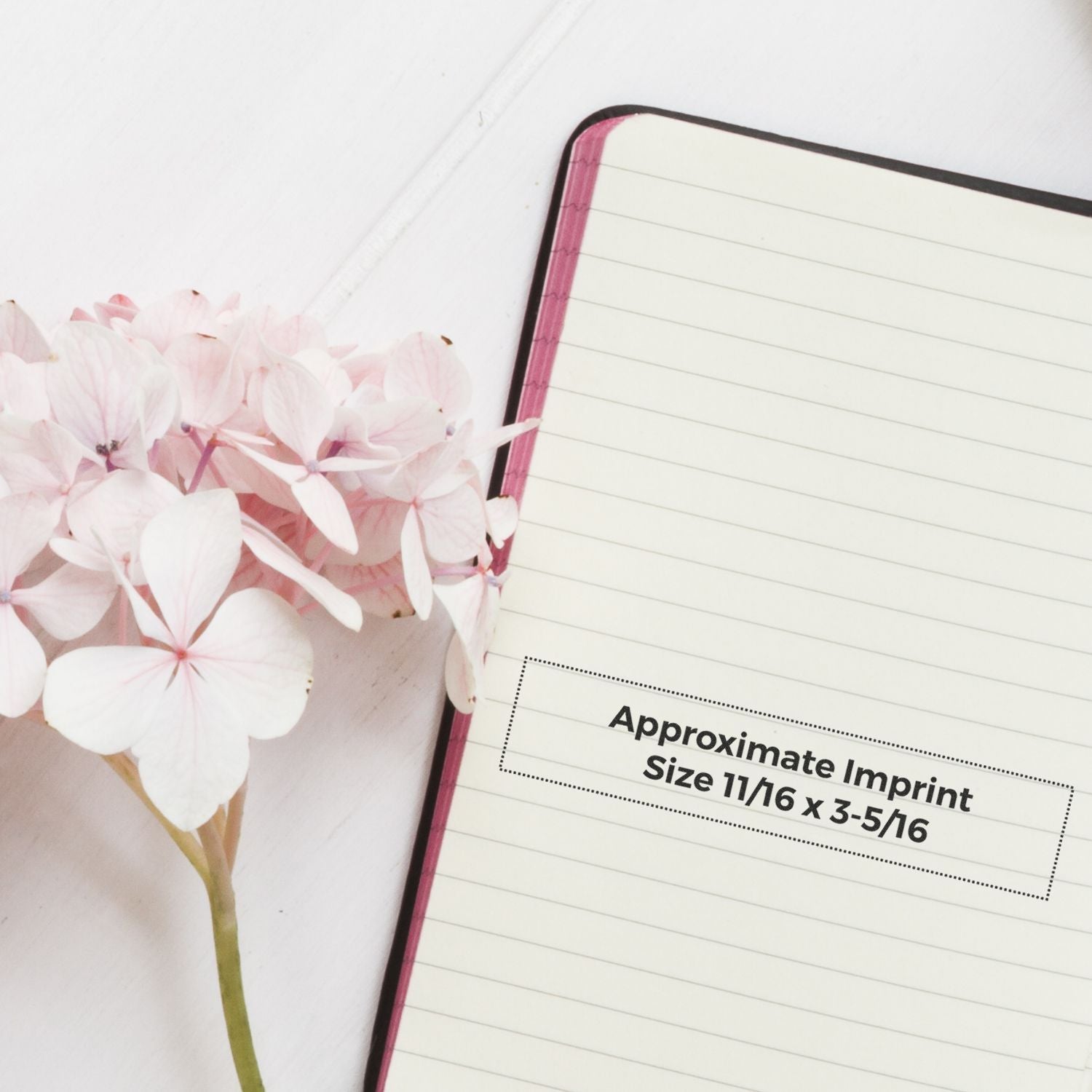Blank notebook with pink hydrangea flowers and imprint size guide, approximate 11/16 by 3-5/16 for custom branding.