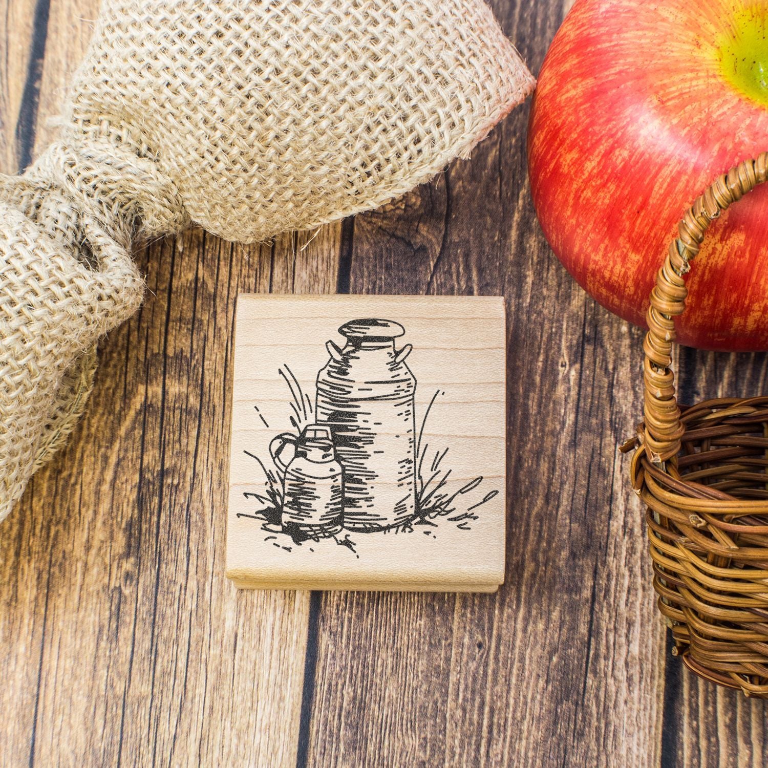 Rustic autumn apple harvest decor with wooden stamp, red apple, basket, burlap, and farmhouse wood background.